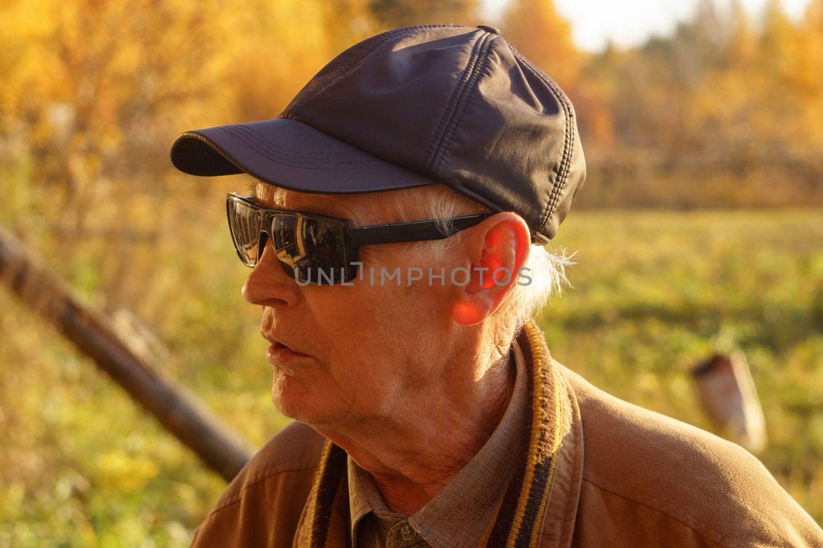 Portrait of an old man wearing sun protection glasses. Old grey haired grandpa central park walk positive enjoy sunny day weather stylish autumn jacket hot.