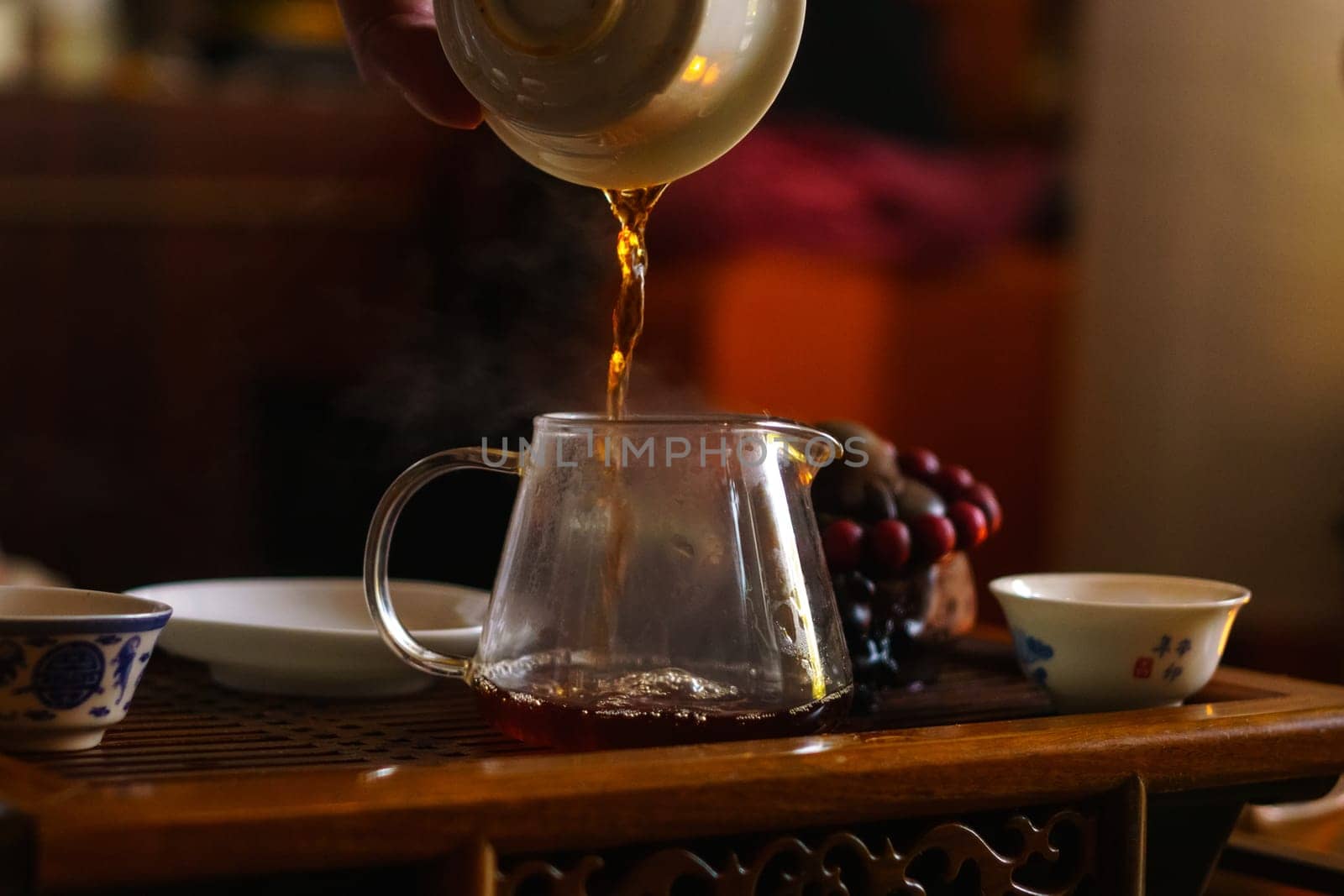 Pouring liquid into a Glass Cup. Selective focus. Tea ceremony by darksoul72