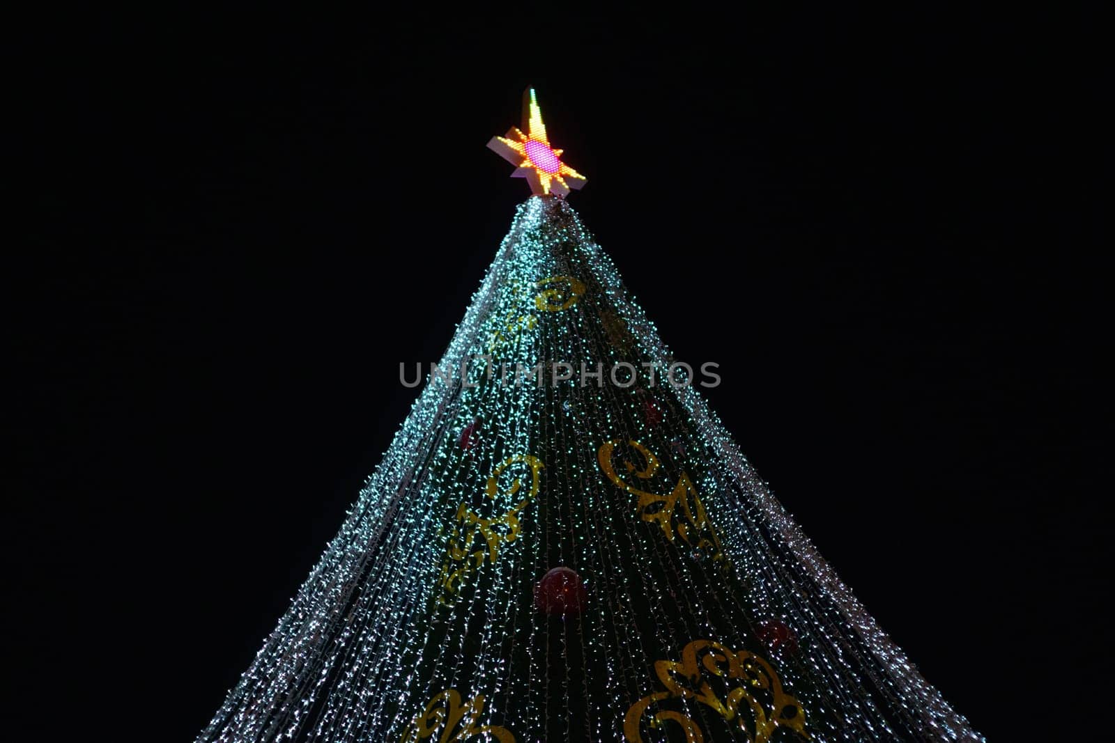 Festive Christmas Tree Illuminated with Twinkling Lights on a Black Background