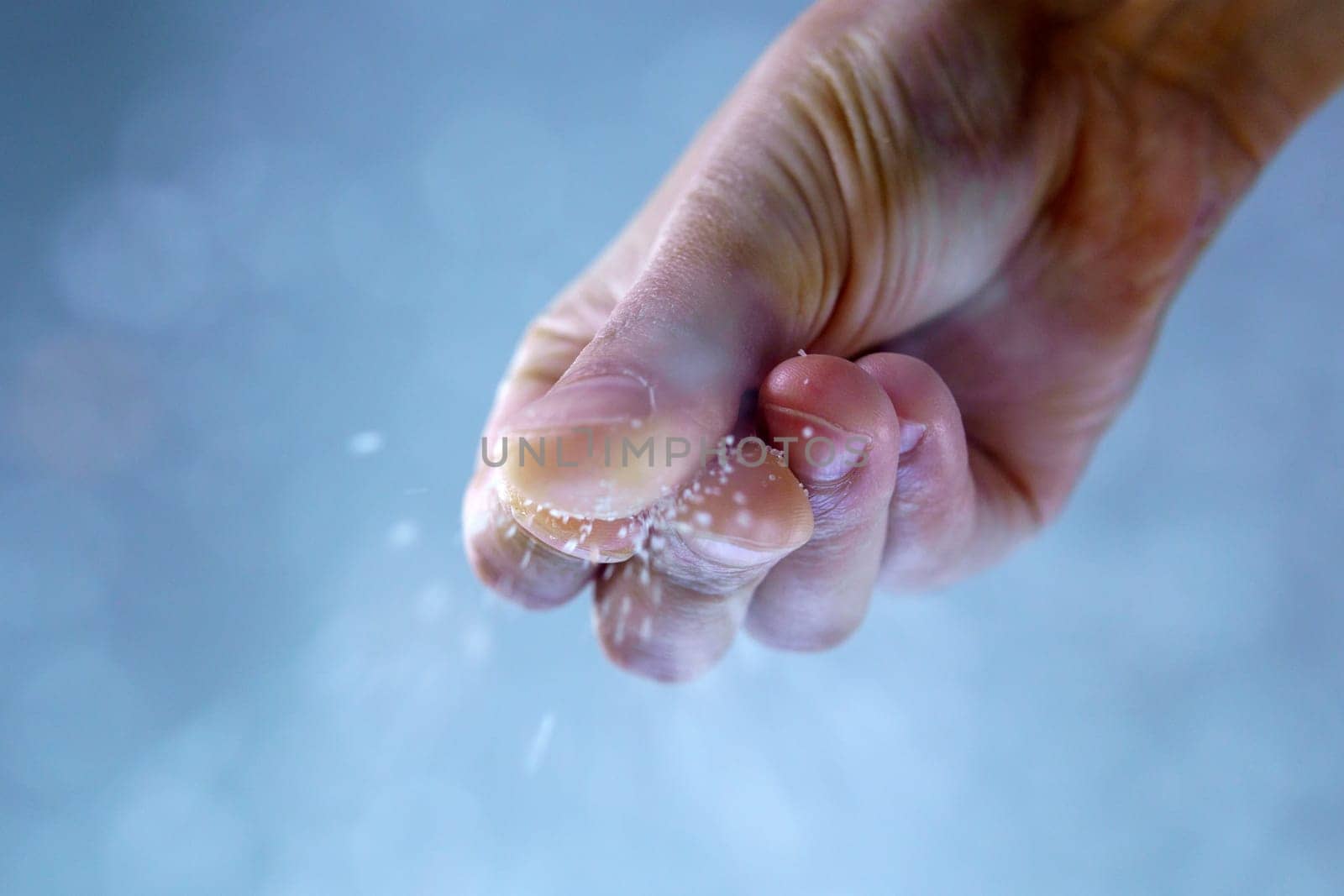 Man adding salt to boiling water in saucepan. Selective focus by darksoul72