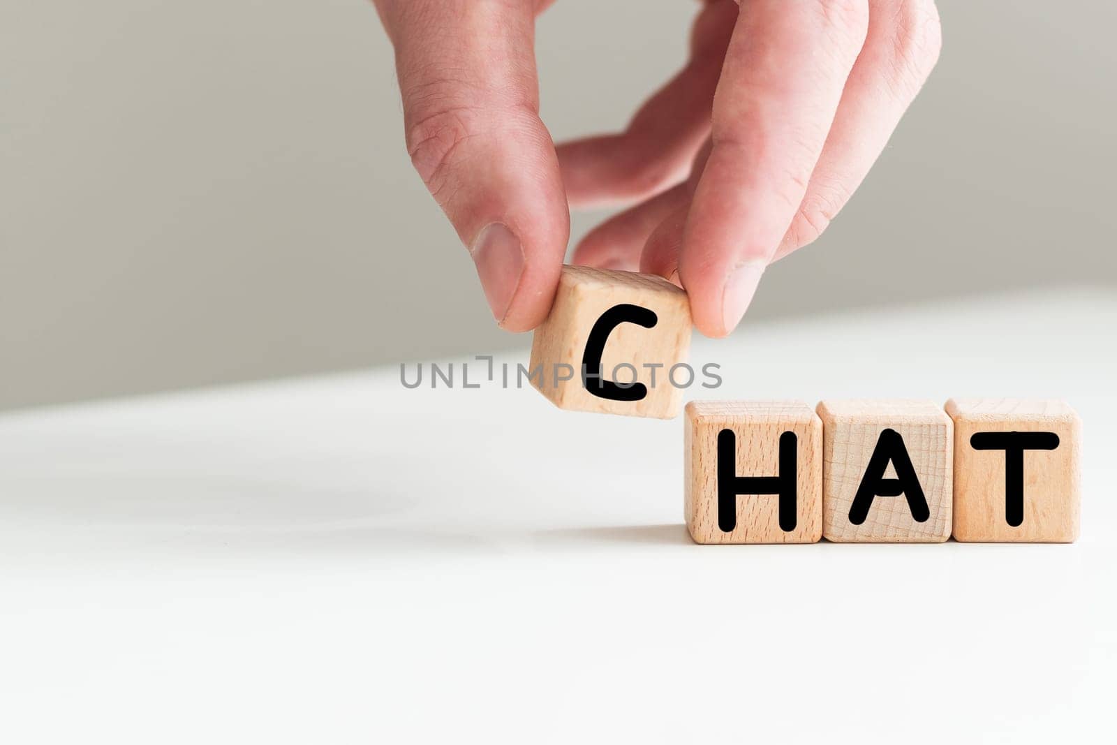 In the man's hand are cubes with the inscription - CHAT. High quality photo