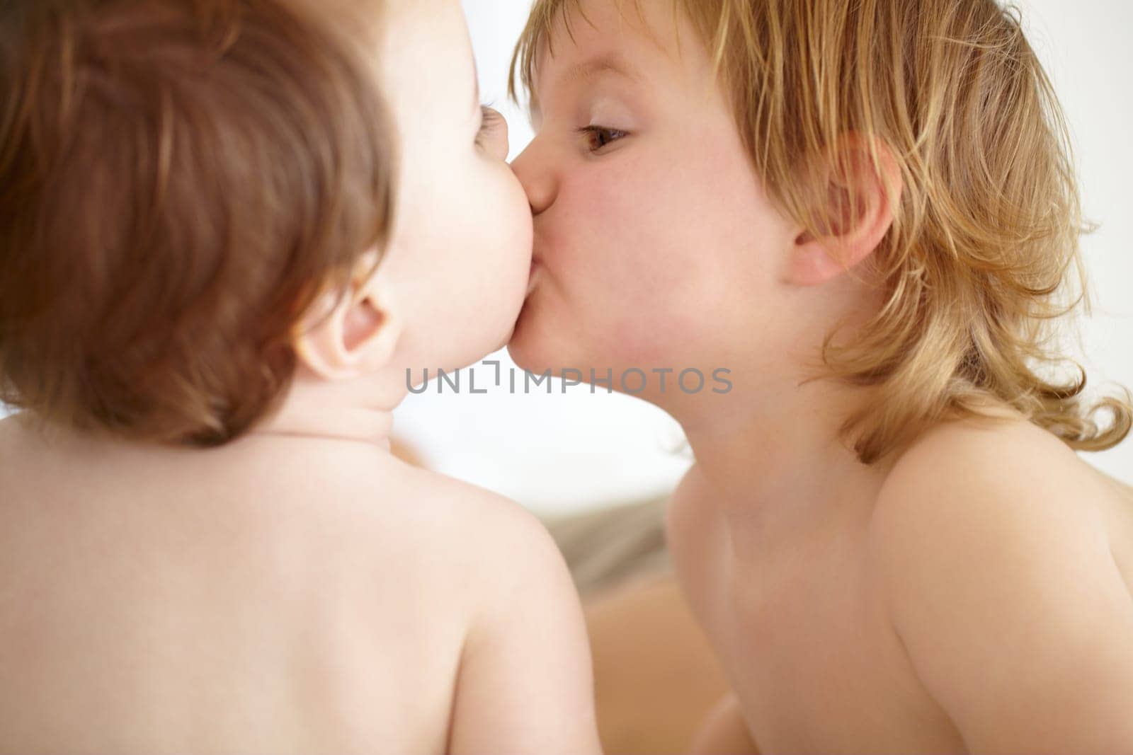 Family, love and baby siblings kissing closeup in their home for love, growth or child development. Kids, together or bonding with an infant child and his brother in a bedroom of their apartment by YuriArcurs