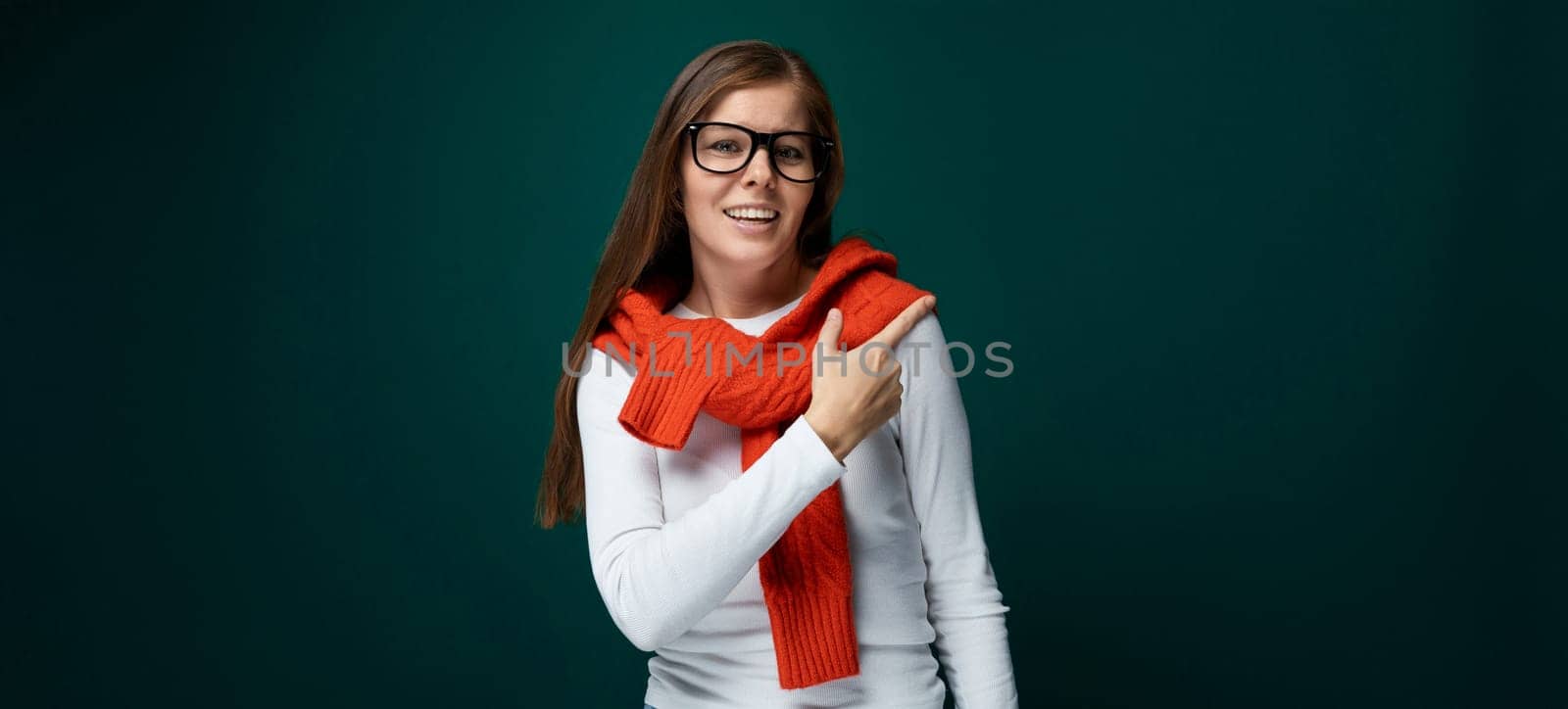 European young woman pointing with hand towards advertisement, business concept by TRMK
