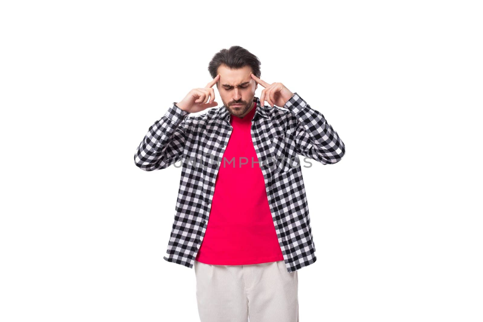 brainstorm. young handsome bearded brunette man in a shirt generates ideas in his head on a white background with copy space.