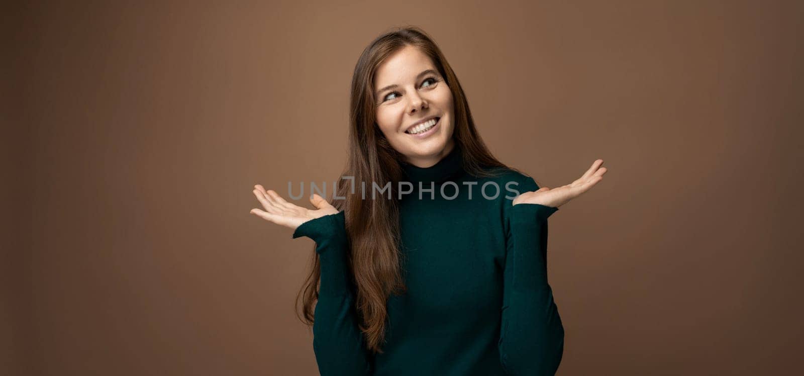 Attractive young woman with healthy brown hair on a brown background with copy space by TRMK