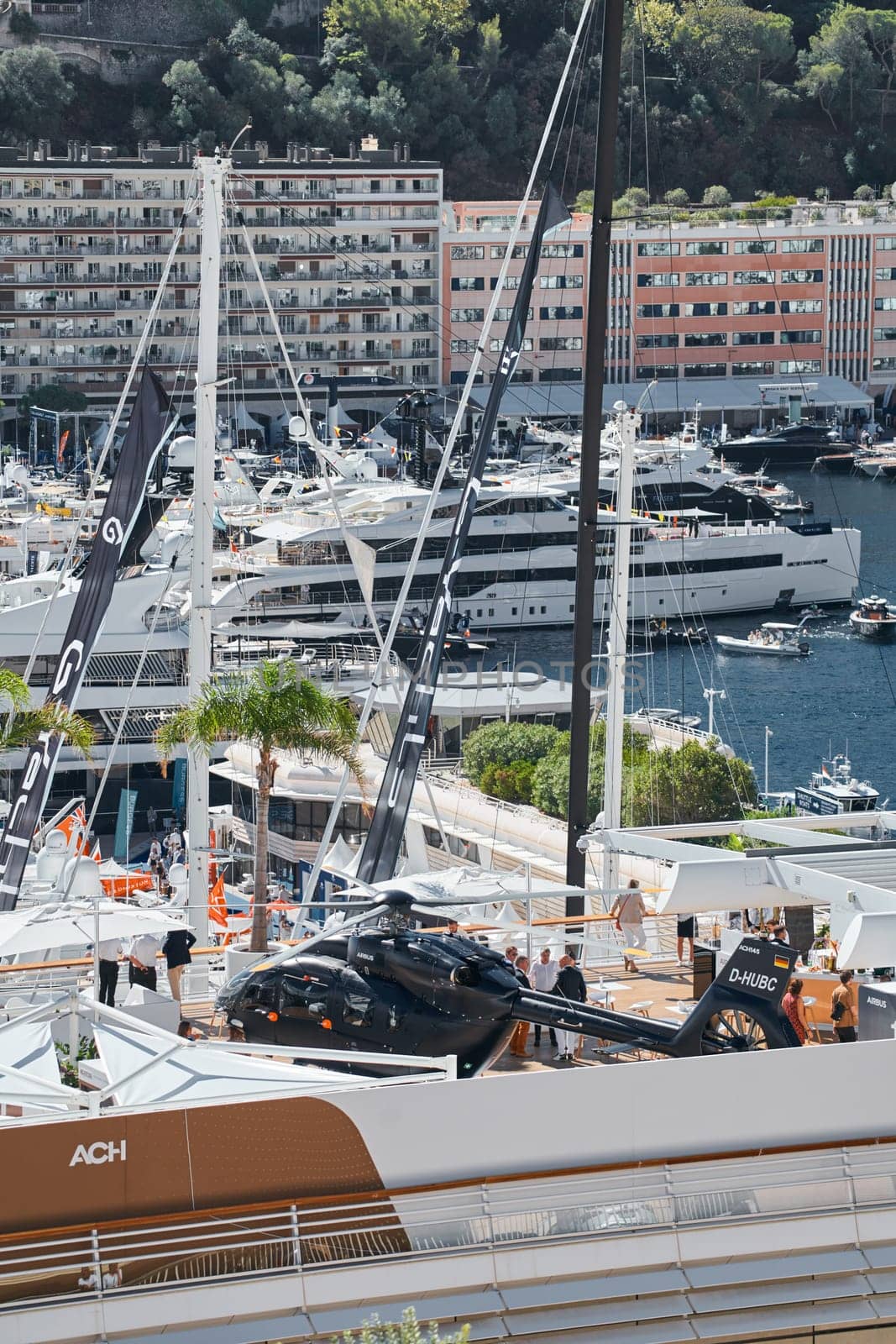 Rich clients visitors examine a helicopter standing on the deck of a yacht club, the largest fair yacht show, port Hercules, yacht brokers, sunny weather by vladimirdrozdin