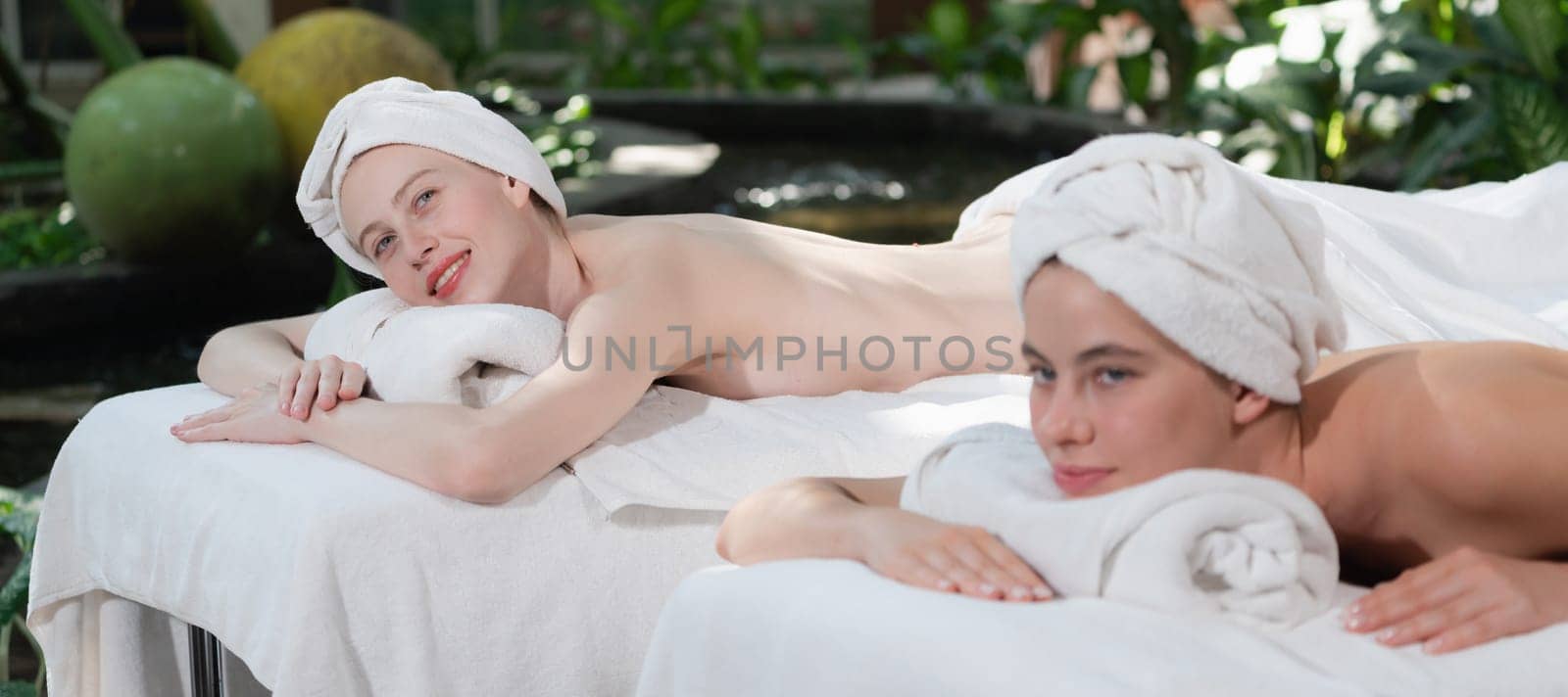 A portrait of a couple of attractive young woman lie on spa bed. Tranquility. by biancoblue