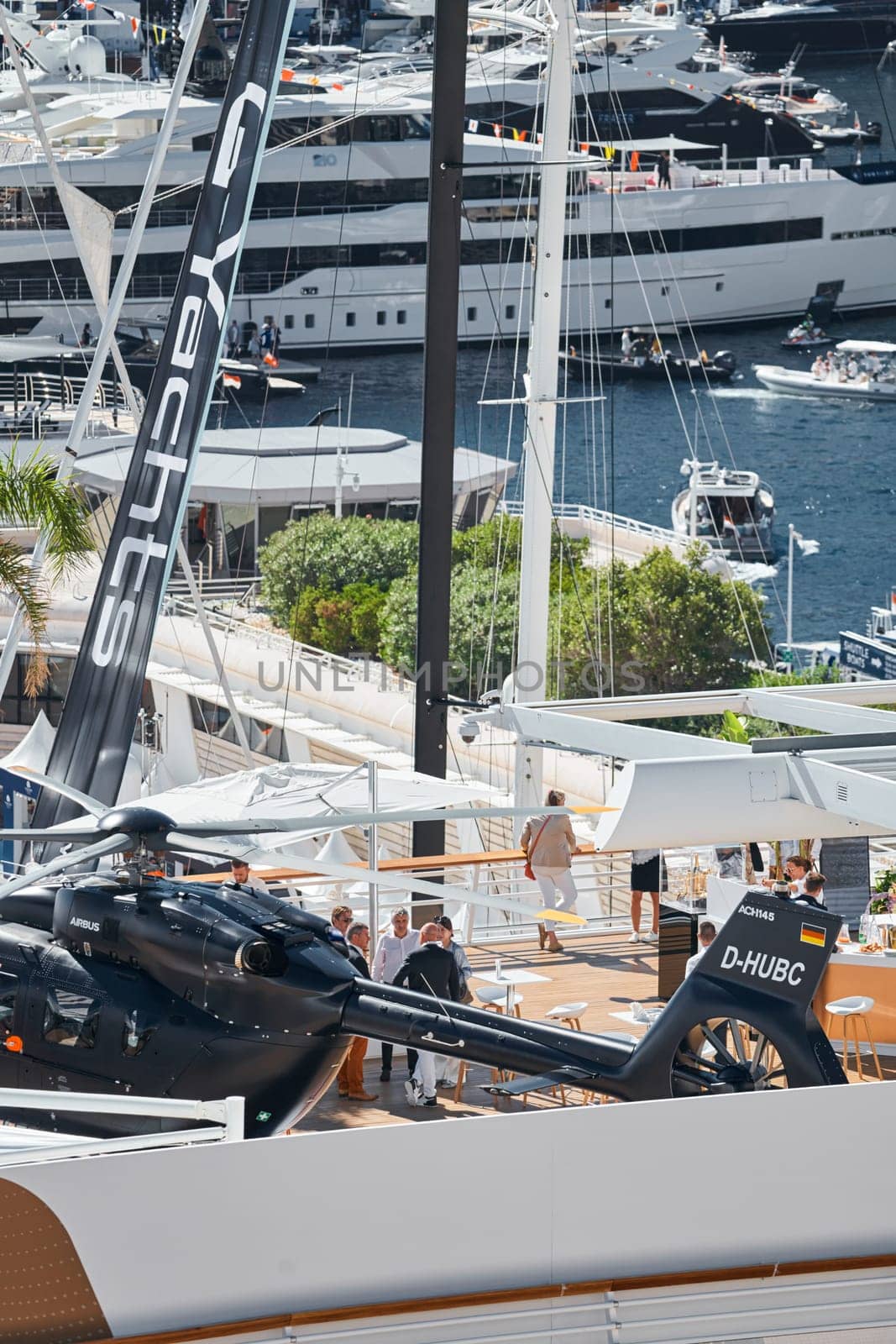 Rich clients visitors examine a helicopter standing on the deck of a yacht club, the largest fair yacht show, port Hercules, yacht brokers, sunny weather by vladimirdrozdin