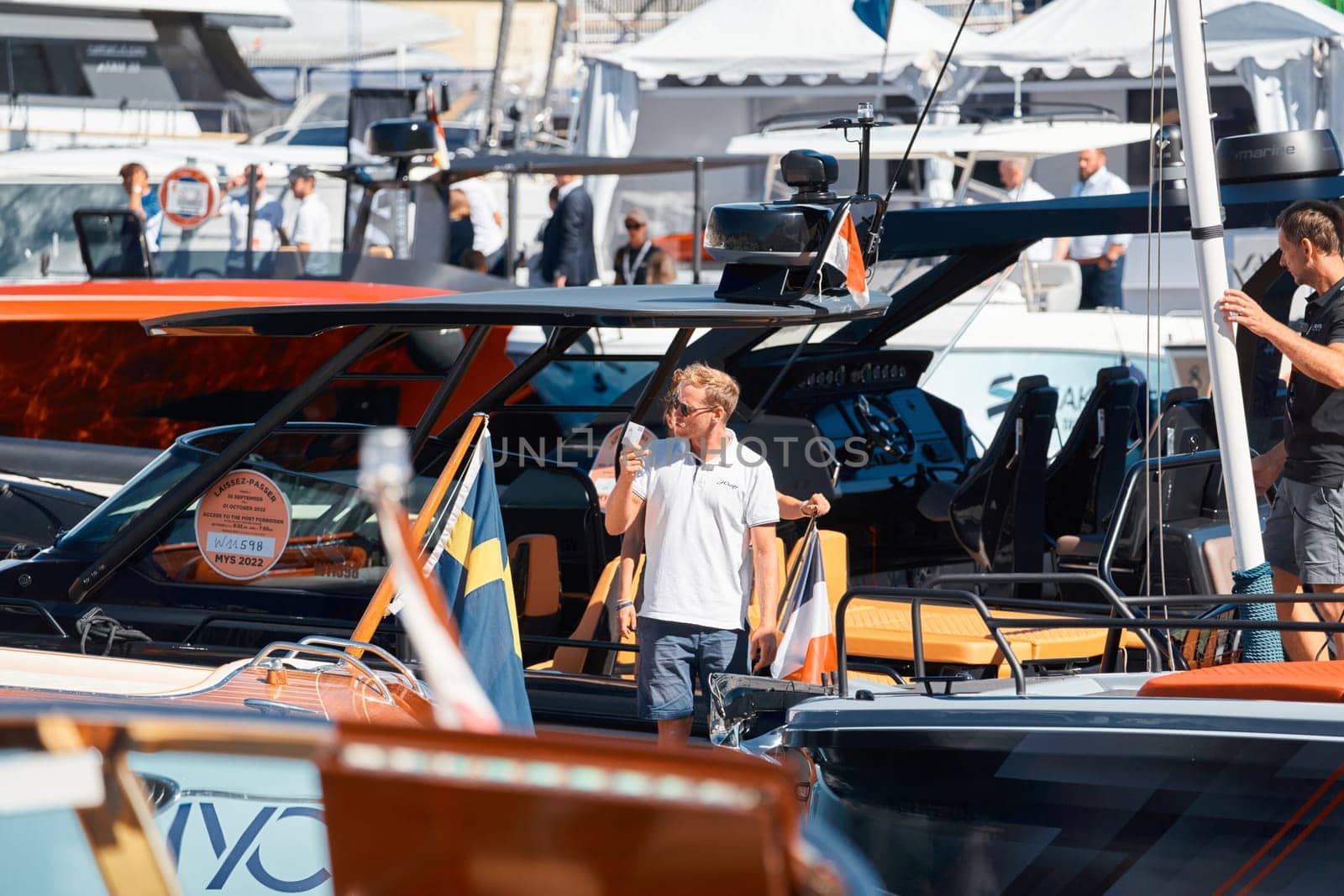 Monaco, Monte Carlo, 28 September 2022 - Invited wealthy clients inspect megayachts at the largest fair exhibition in the world yacht show MYS, port Hercules, yacht brokers, sunny weather. High quality photo