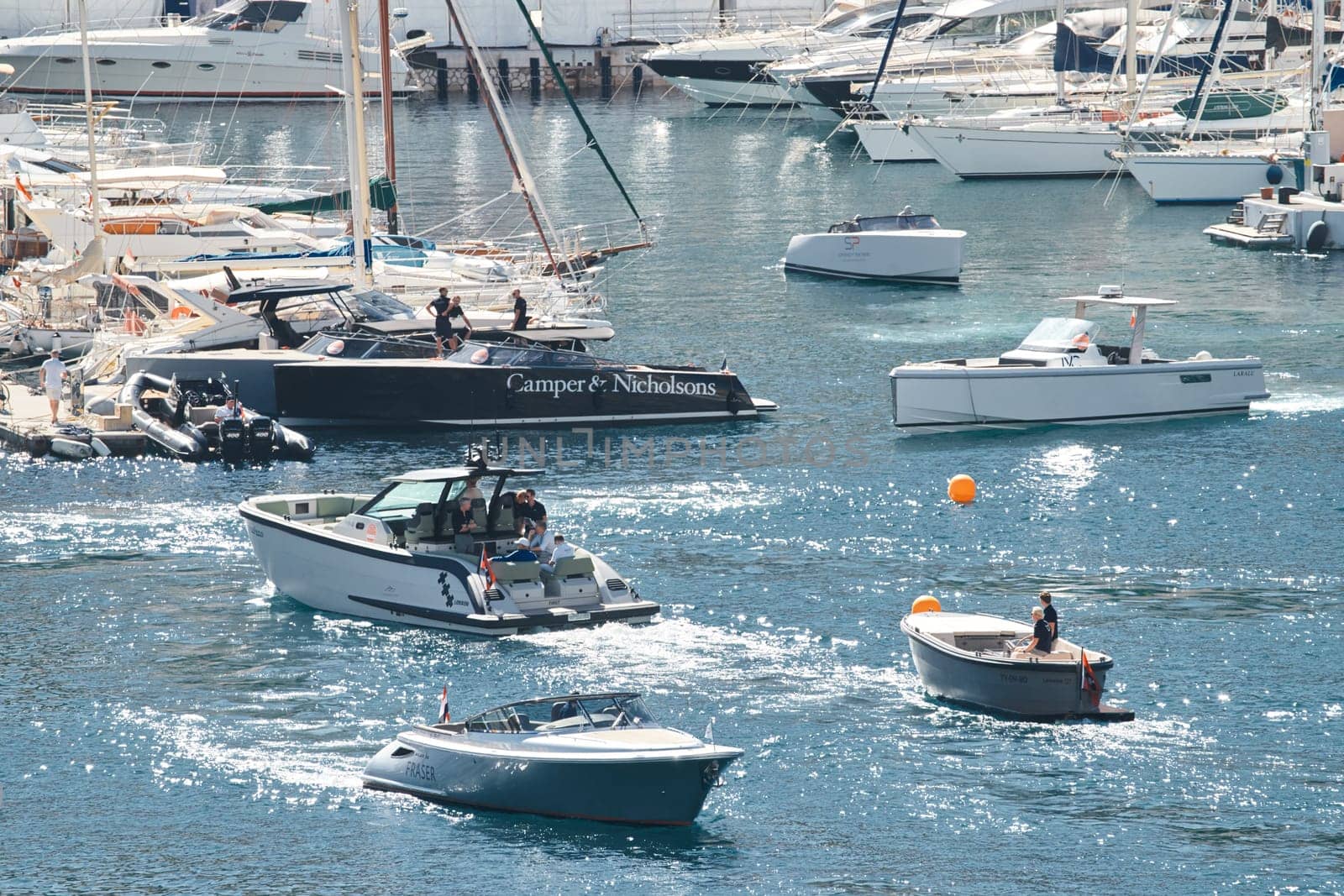 a boat with guests of yacht brokers departs from the shore in the largest fair exhibition in the world yacht show MYS, port Hercules, rich clients, sunny by vladimirdrozdin