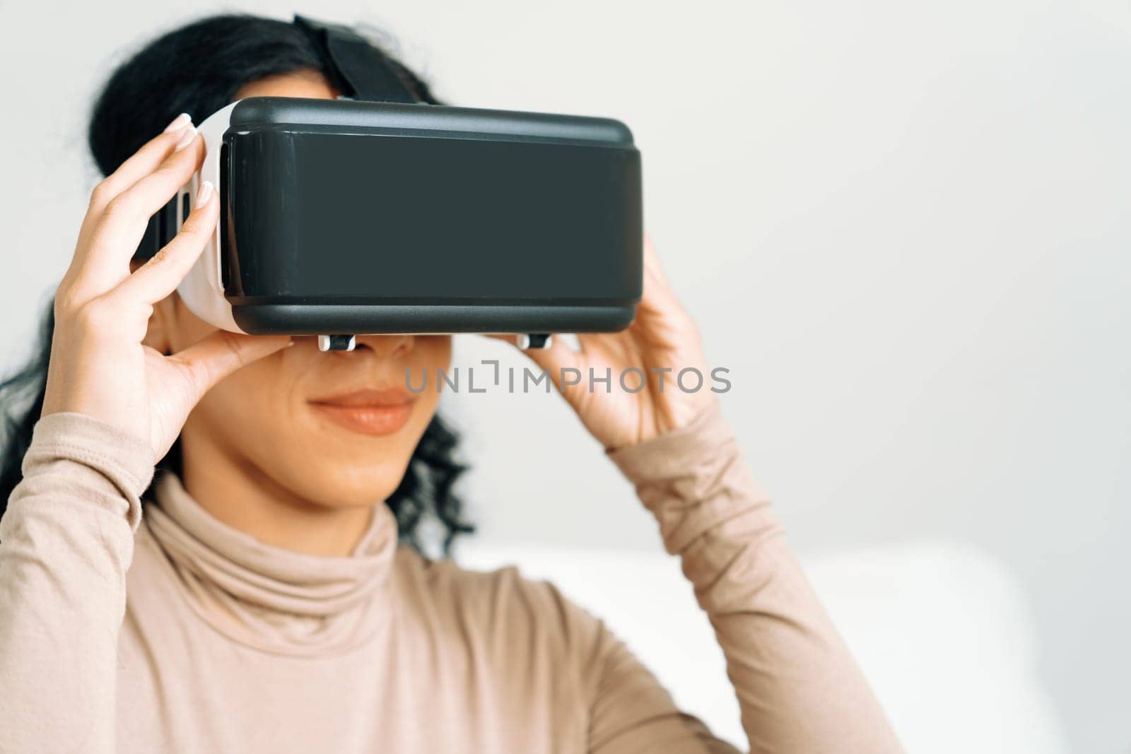 Young woman using virtual reality VR goggle at home for crucial online shopping experience. The virtual reality VR innovation optimized for female digital entertainment lifestyle.
