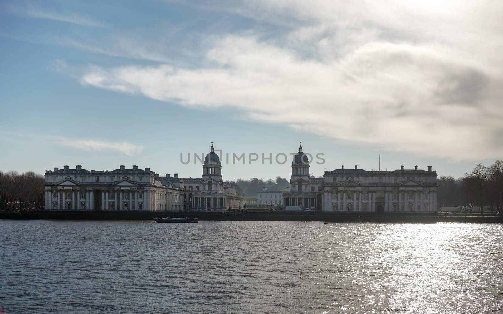 Royal Hospital School) over river Thames, on winter morning - strong sun backlight reflects in water.