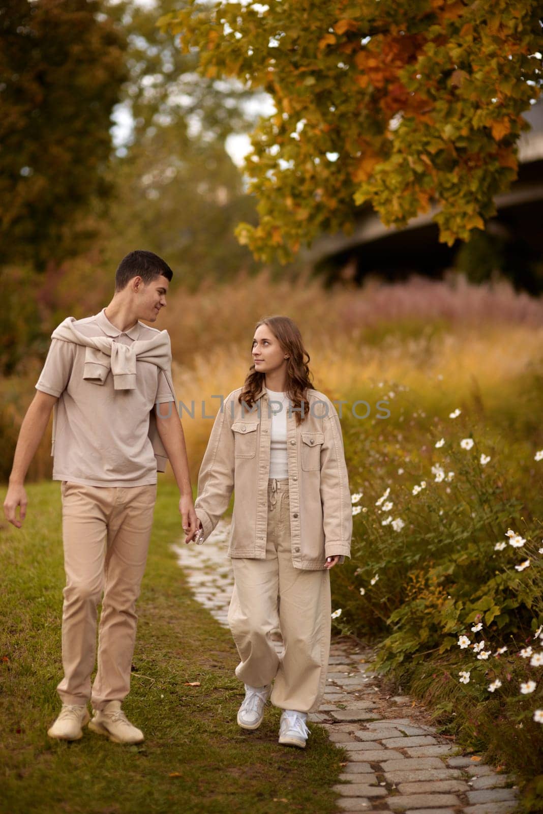 Young Cute Female Hugs Boyfriend. In Autumn Outdoor. Lovers Walking in Park. Attractive Funny Couple. Lovestory in Forest. Man and Woman. Cute Lovers in the Park. Family Concept. Happy Couple.