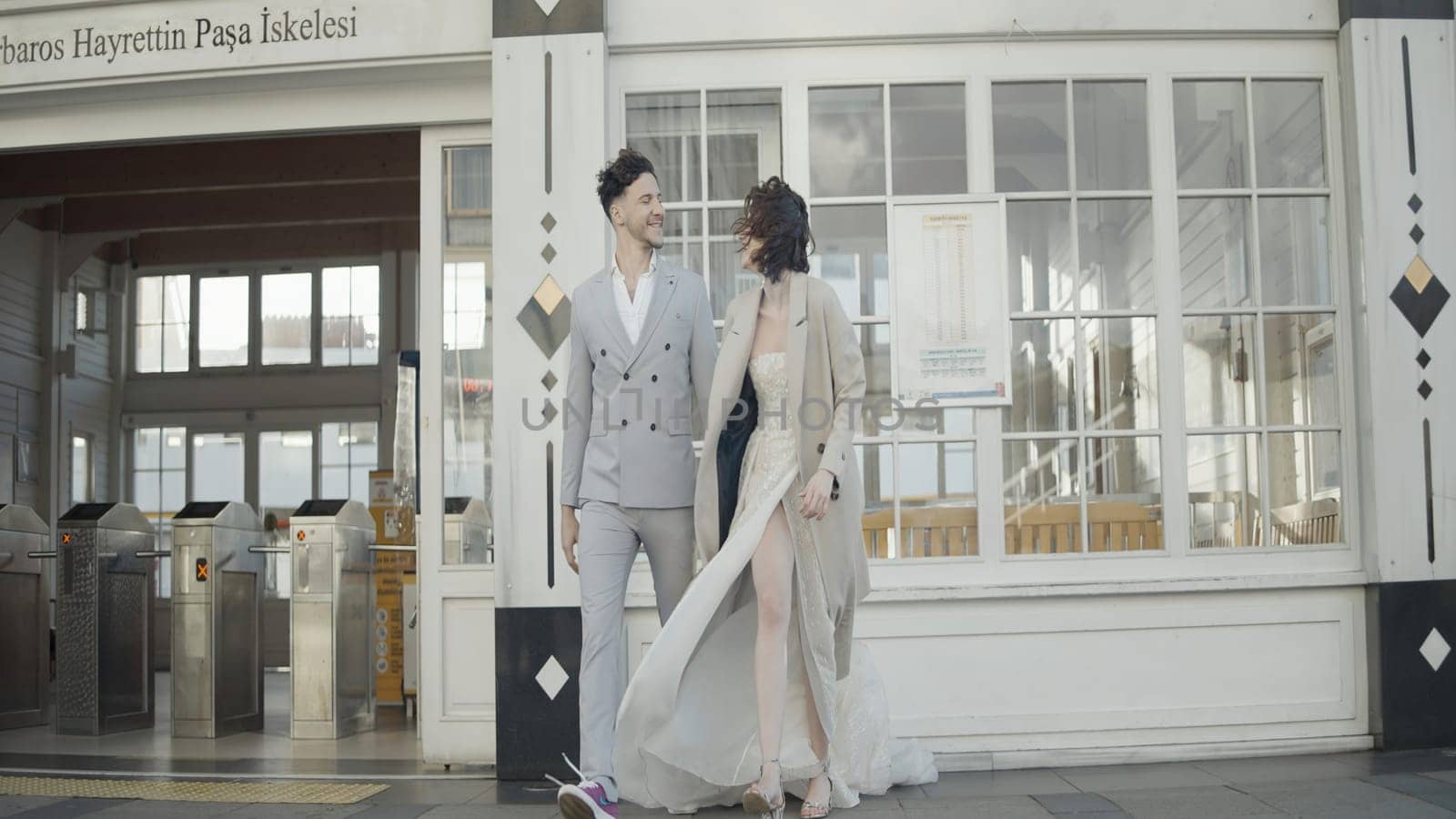 Stylish and happy couple in suits. Action. Beautiful couple is laughing on city street. Couple in stylish outfits smiling happily by Mediawhalestock