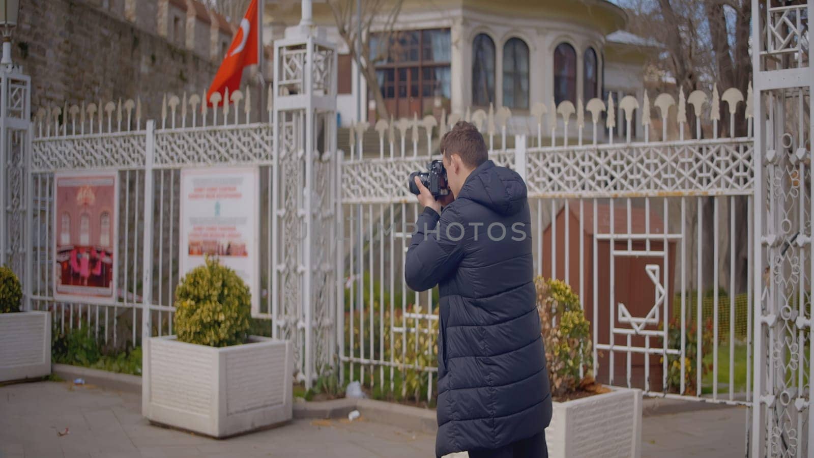 Photographer shoots architecture on camera. Action. Professional male photographer walks around city and shoots landscapes. Man walks around city with professional camera.