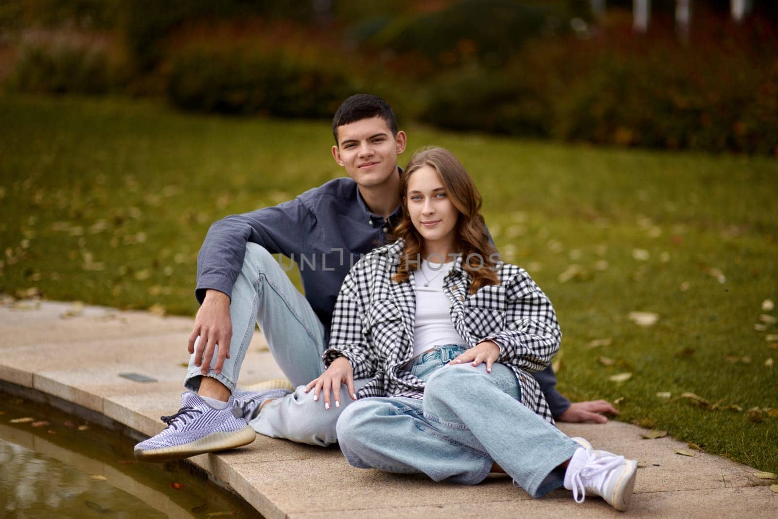 lovely young couple kissing outdoors in autumn. Loving couple walking in nature. Autumn mood. Happy man and woman hugging and kissing in autumn. Love. Fashionable couple outdoors. Fashion, people and lifestyle. Stylish couple in autumn outfit.