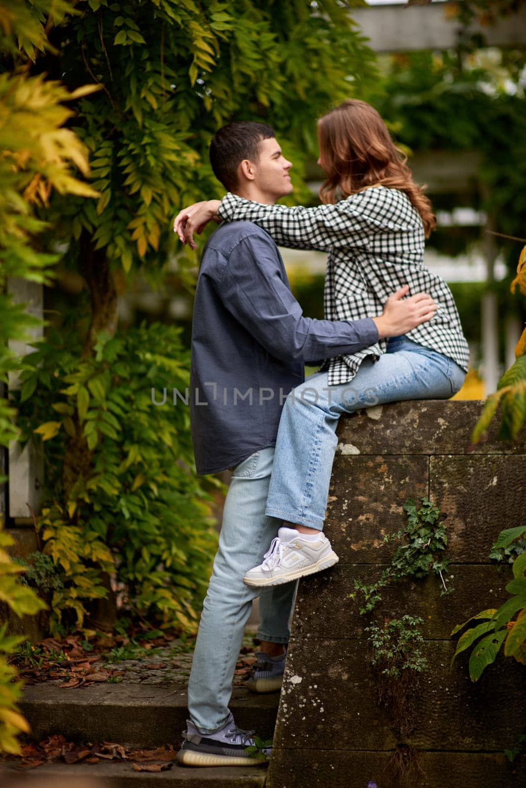 Joyful Autumn Embrace: Cute Lovers Strolling in the Park. Young Cute Female Hugs Boyfriend. In Autumn Outdoor. Lovers Walking in Park. Attractive Funny Couple. Lovestory in Forest. Man and Woman. Cute Lovers in the Park. Family Concept. Happy Couple.