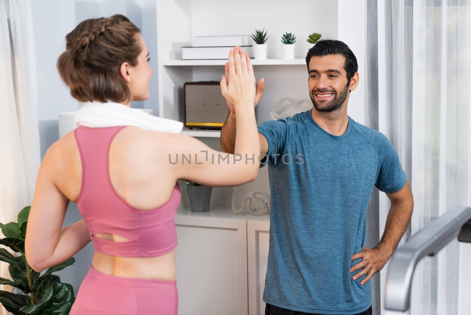 Athletic body and sporty young couple or workout buddy in sportswear high five after successful in home workout exercise at gaiety home exercise and healthy lifestyle concept.