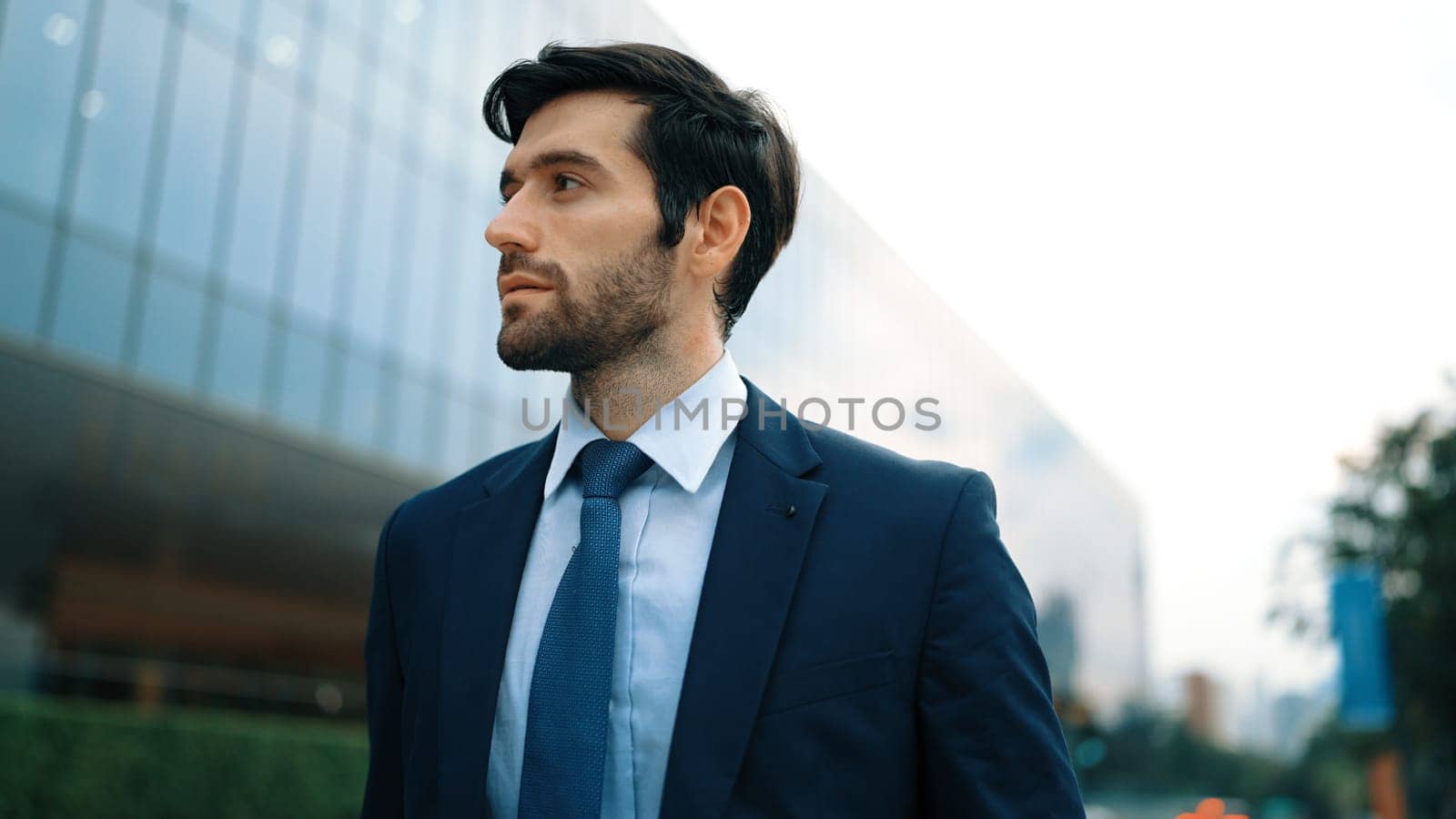 Closeup portrait of business man standing at camera at city view. Exultant. by biancoblue