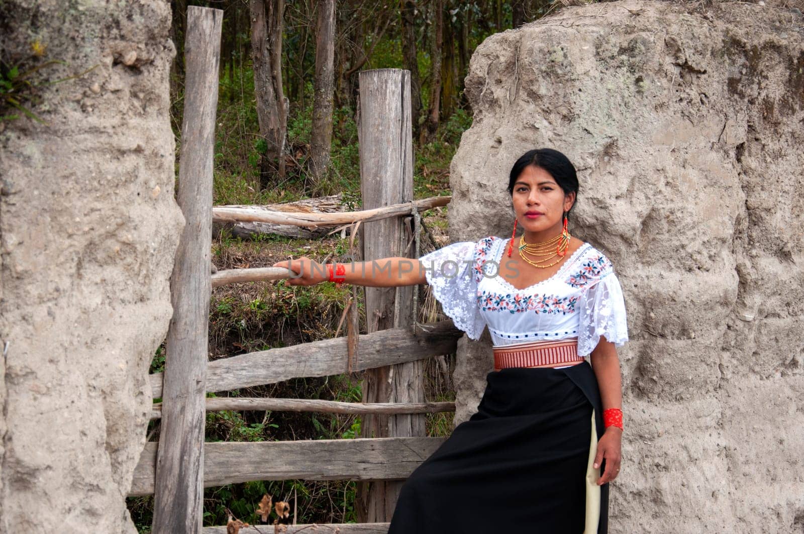 indigenous woman at the door of her house wearing traditional dress of her ecuadorian culture. High quality photo
