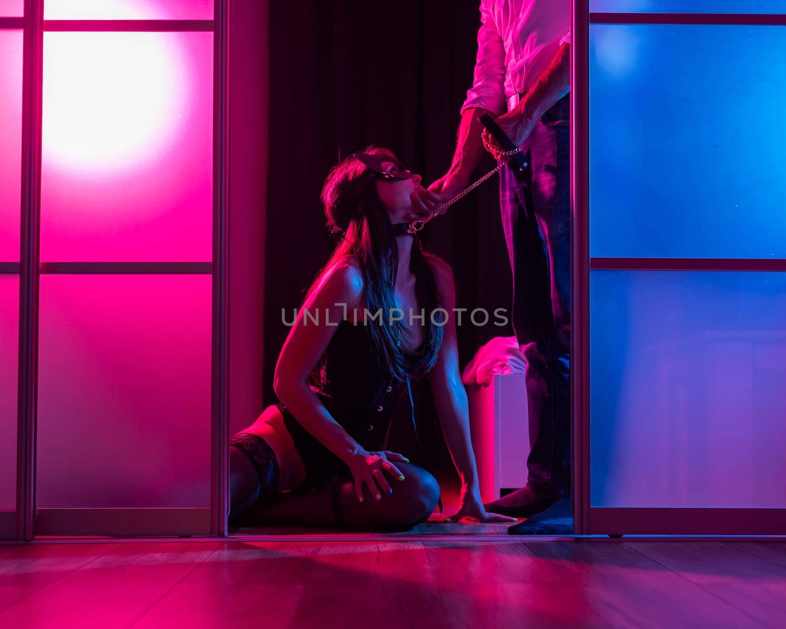 A woman is kneeling in front of a man. BDSM sex concept. Vertical photo. by mrwed54
