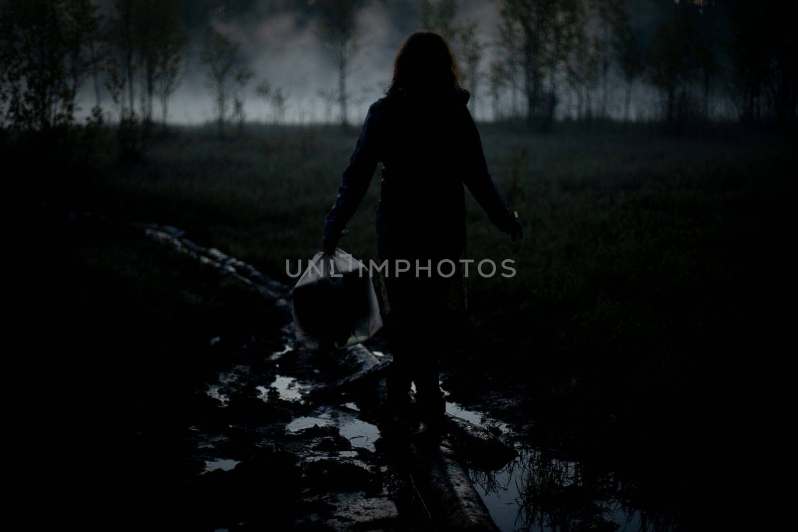 Girl walks in fog in morning. Rest in wild. Fog in swamp. by OlegKopyov