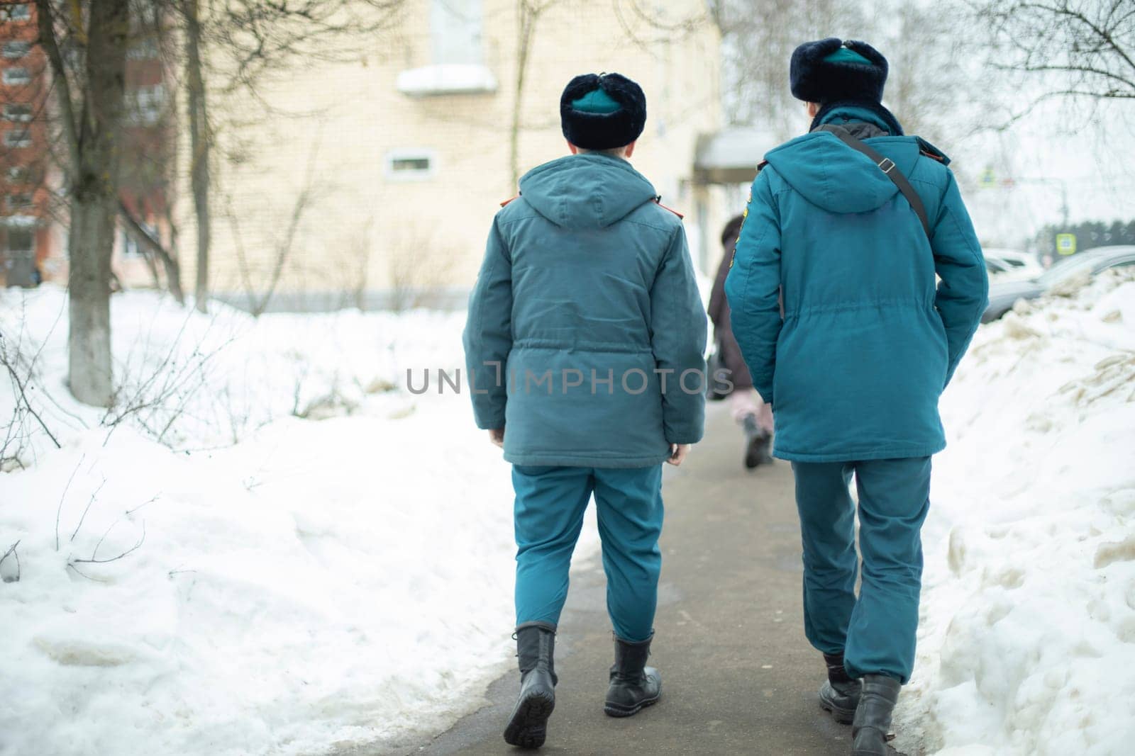 Two guys in uniform. Men come from service in Russia. People in warm clothes in Siberia. Blue shape. by OlegKopyov