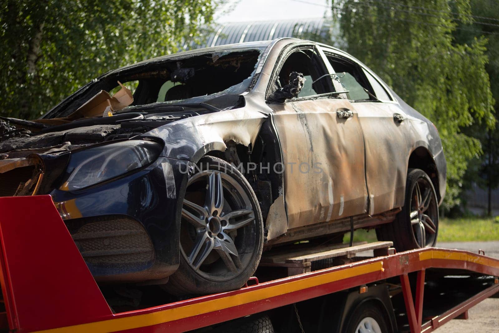 Burned-out car. Evacuation of vehicles after accident. Transportation of machine. Burnt metal. by OlegKopyov