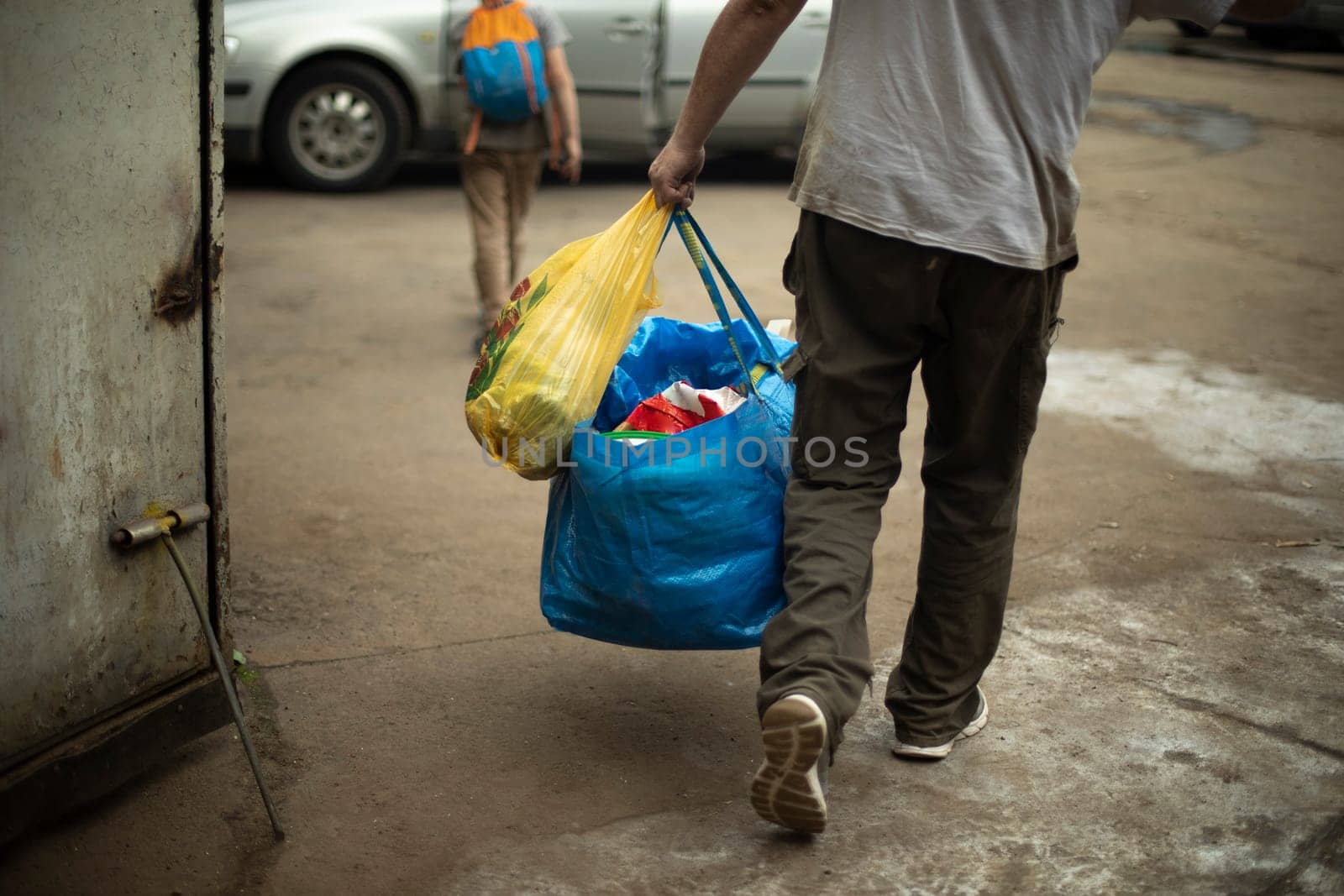 Man carrying blue bag. Moving with things. Guy dragging things. by OlegKopyov