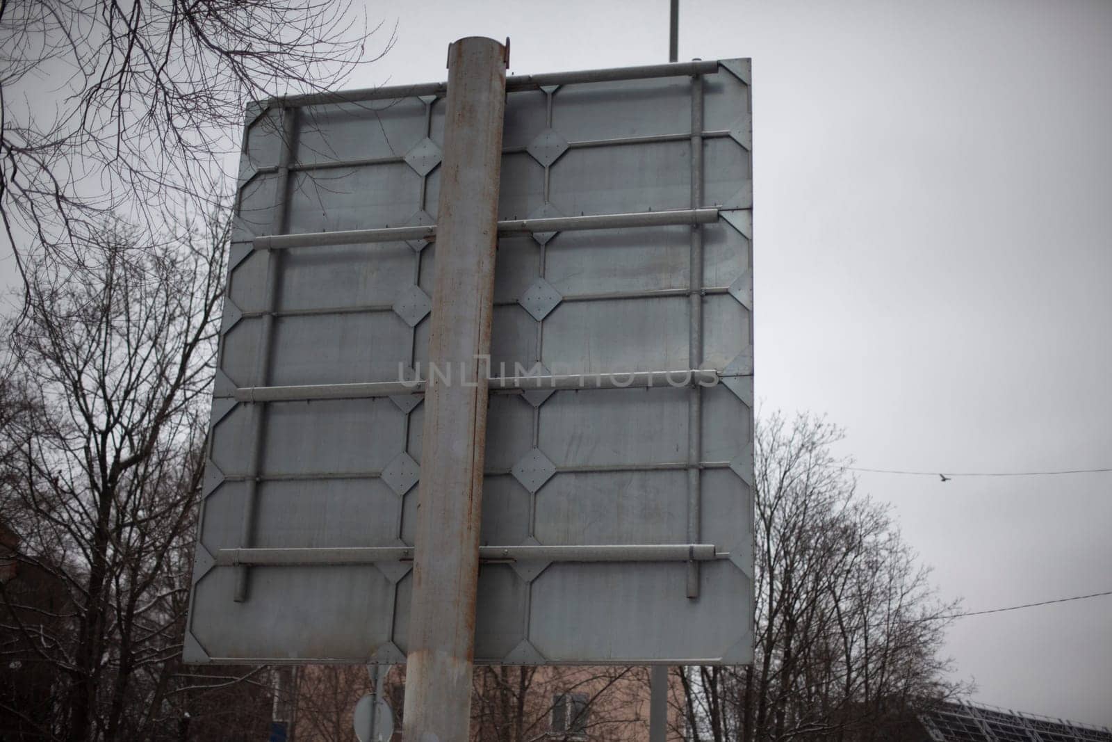 Road sign at the back. A pole with a sign on the reverse side. The design of the road sign. Steel shield.