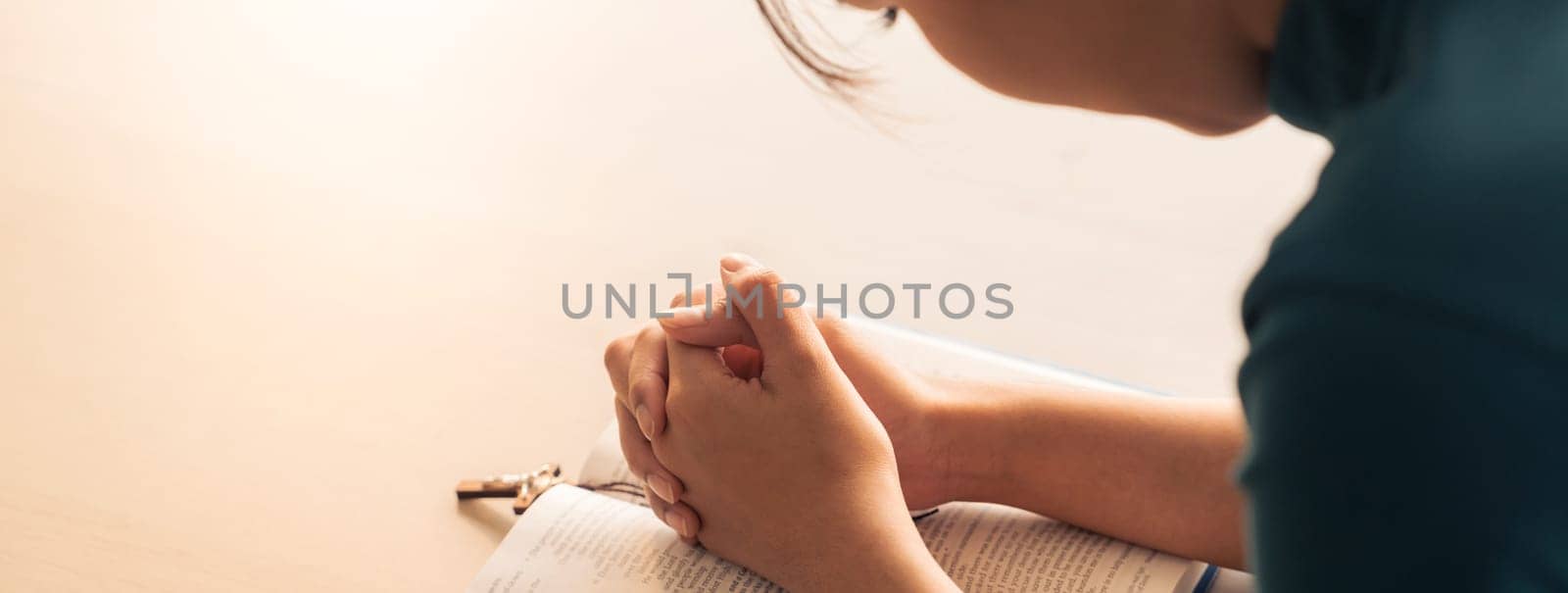 Female folding hand pray to god faithfully with believe in god blessing to happiness at wooden church. Concept of hope, religion, christianity and god blessing. Warm and brown background. Burgeoning.