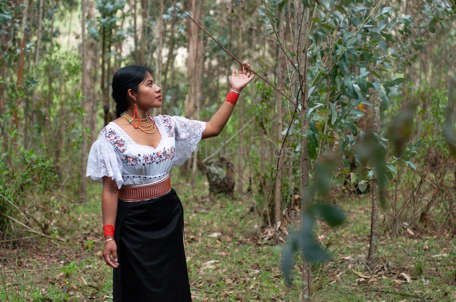 beautiful latin american indian woman emotionally connecting with nature in a forest. earth day by Raulmartin