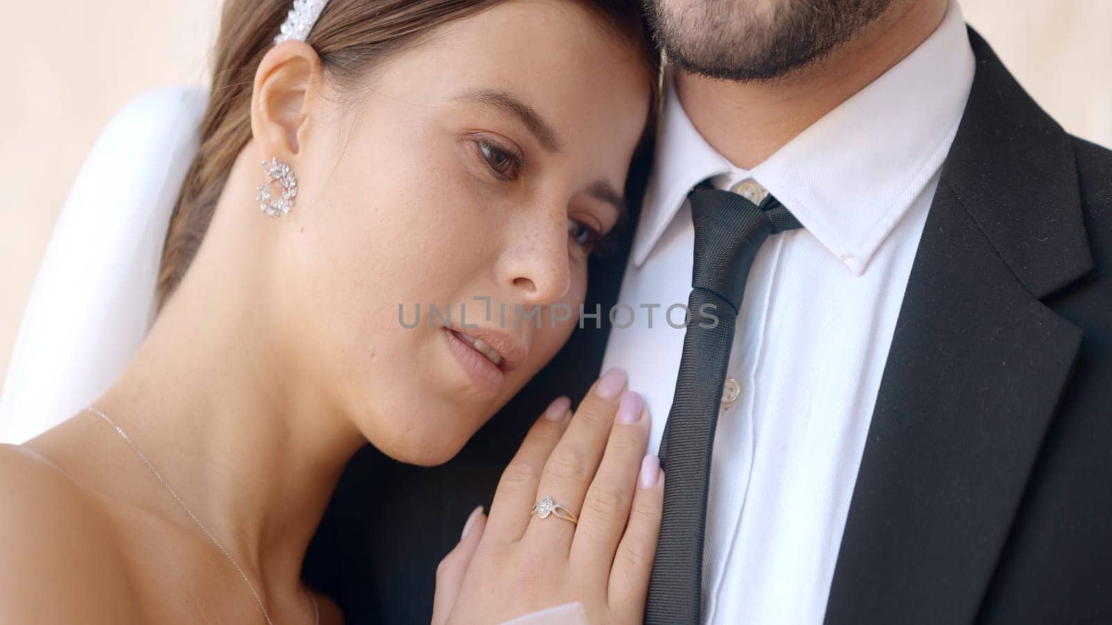 Close-up of bride gently embracing groom. Action. Husband gently embraces beautiful bride. Gentle and reliable embrace of newlyweds.