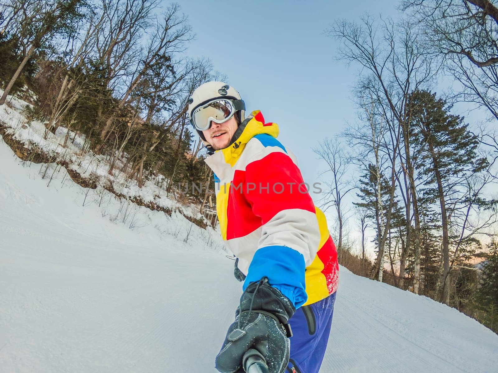 A daring man conquers snowy slopes with style, showcasing skill and thrill as he maneuvers on a snowboard, capturing the essence of winter adventure by galitskaya