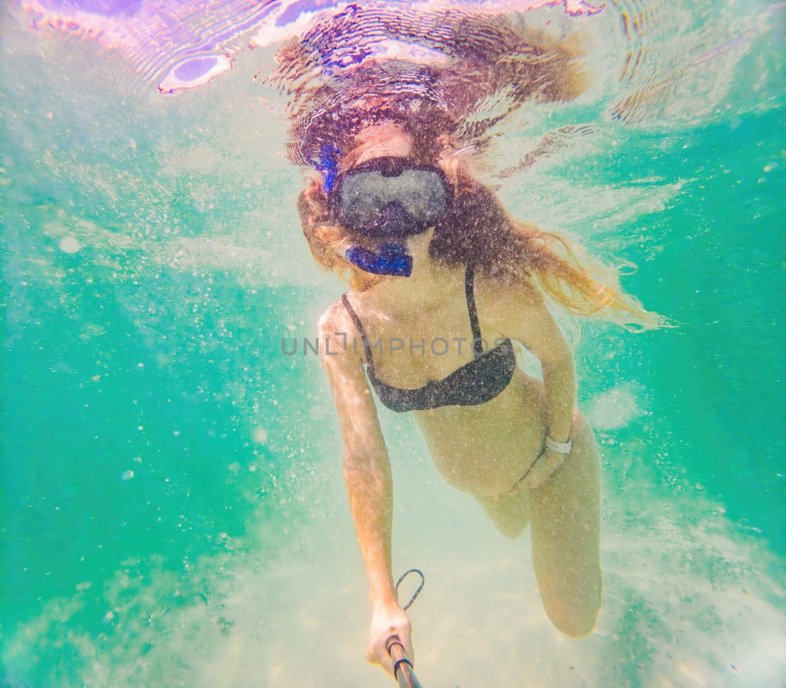 In an ethereal underwater scene, a pregnant woman gracefully floats, embodying the beauty of maternity beneath the tranquil surface of the sea.