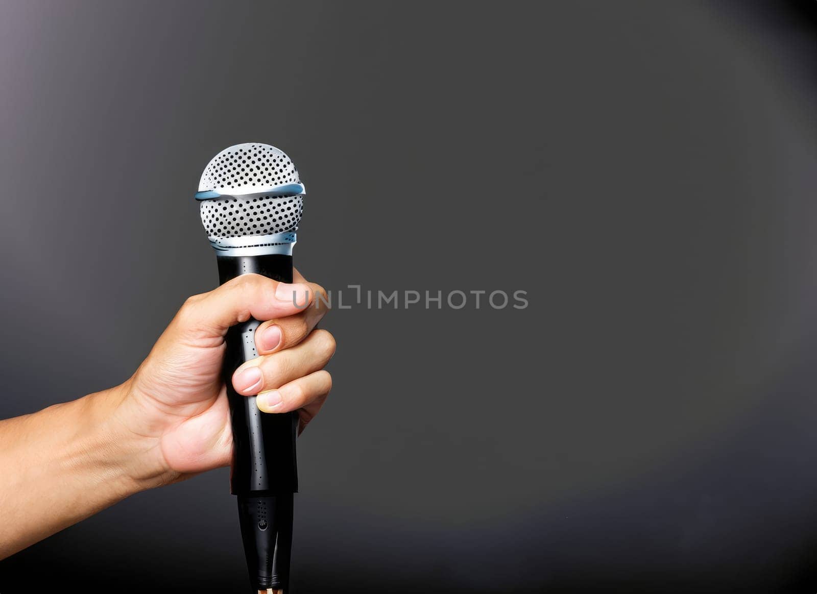  hand with microphone on gray background, close o