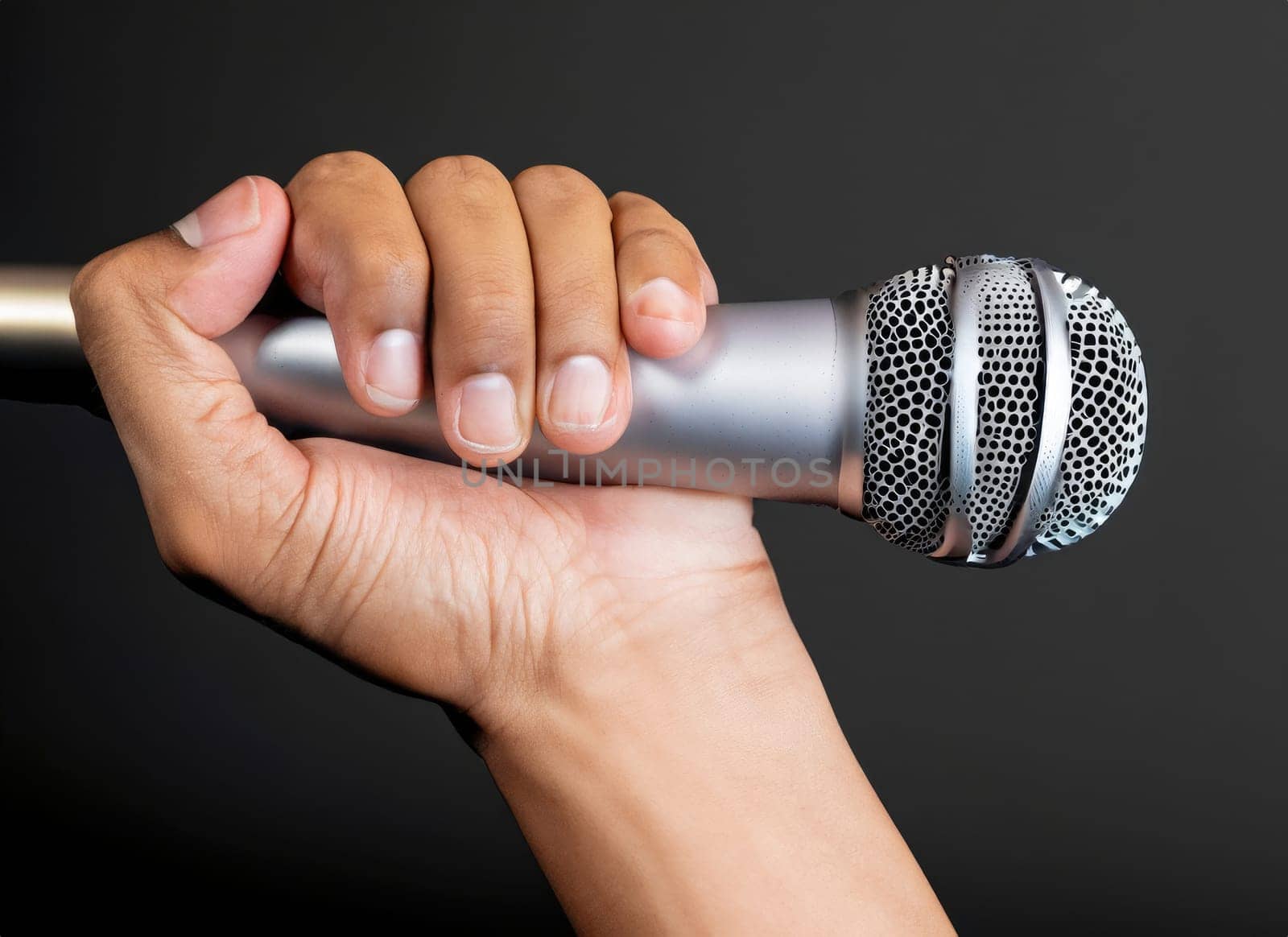  hand with microphone on gray background, close o