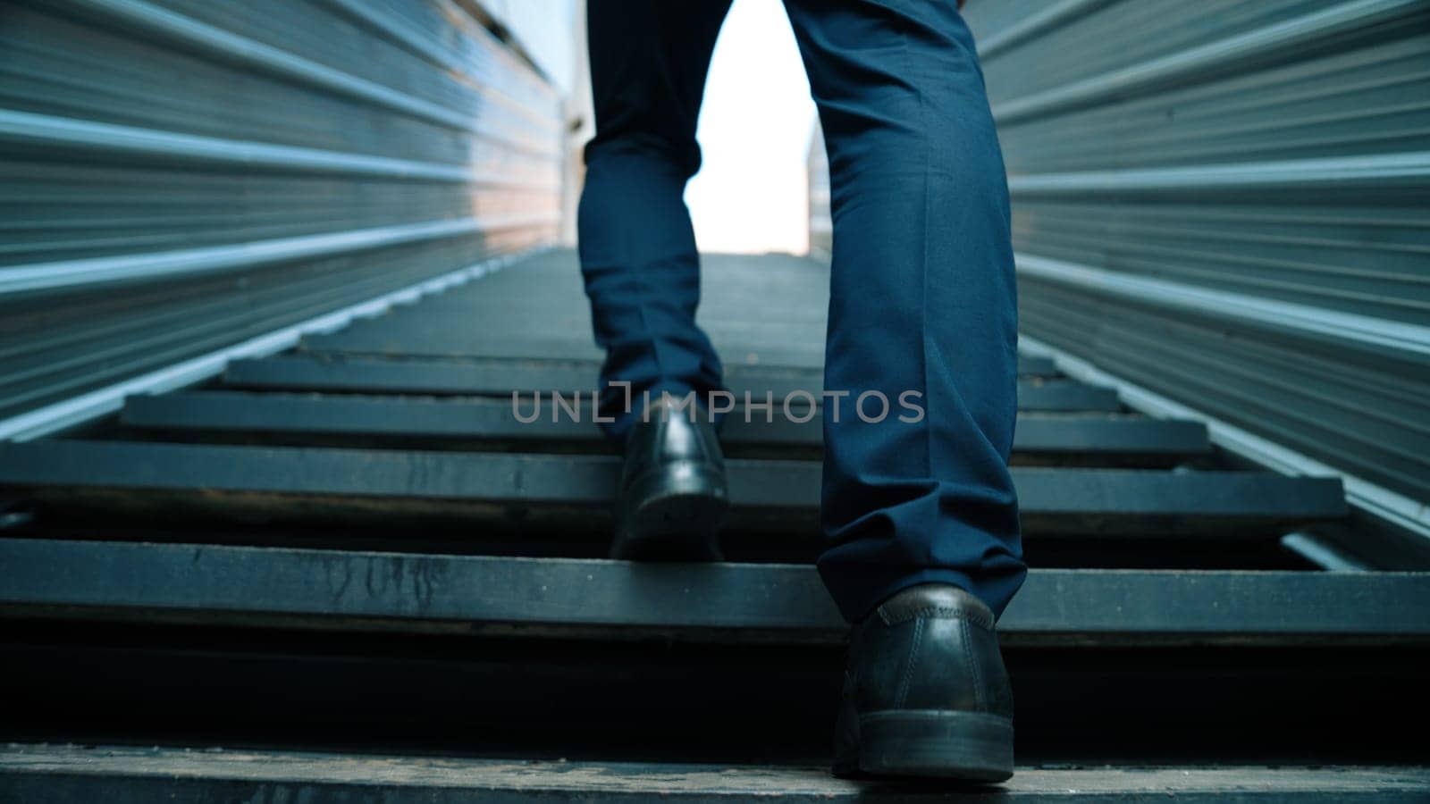Closeup image of successful business man leg walking up to stair. Project manager changing workplace, discover a new thing, growth or getting promotion or walking in to light. Rising up. Exultant.