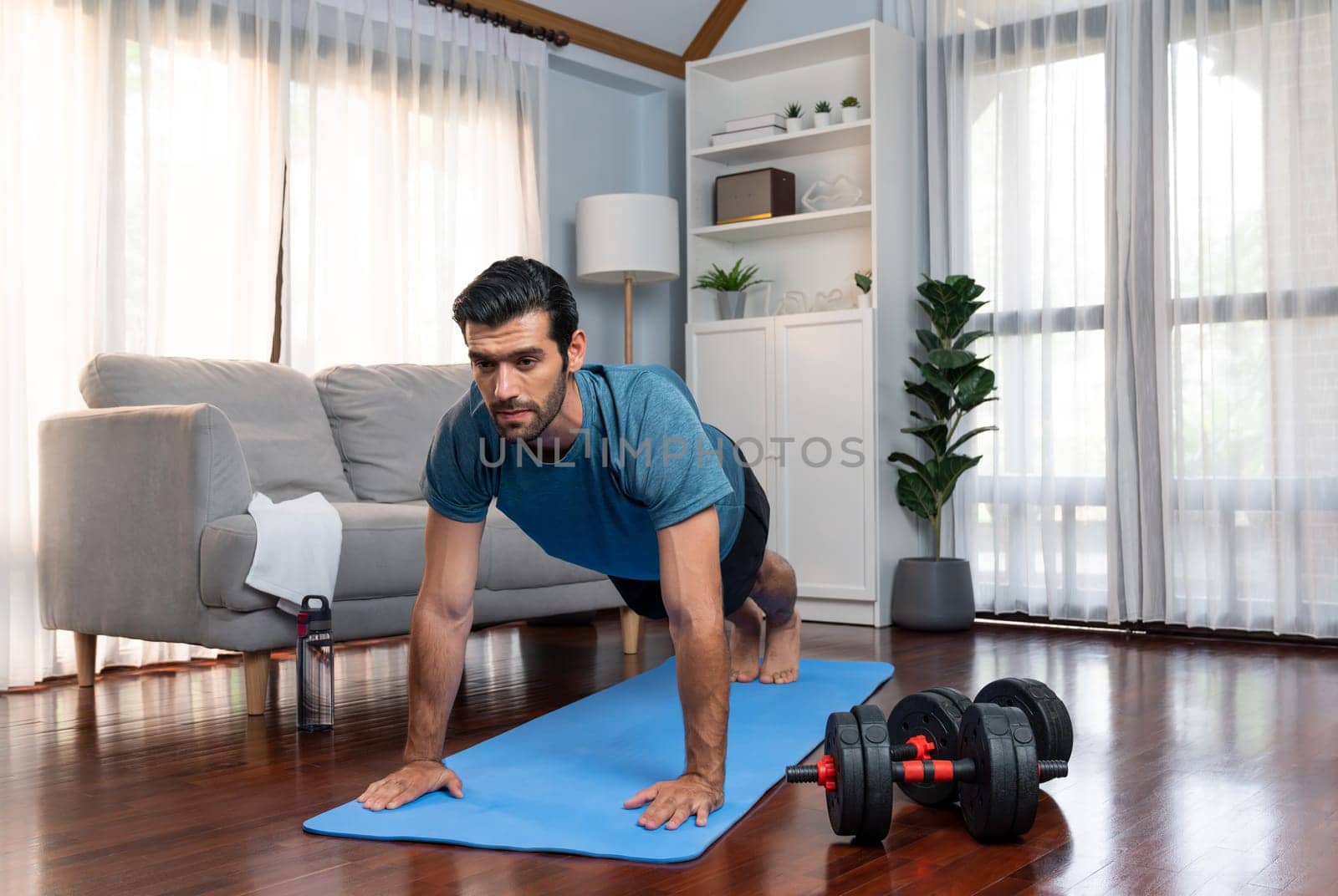 Athletic and sporty man doing pushup on fitness mat at gaiety home. by biancoblue