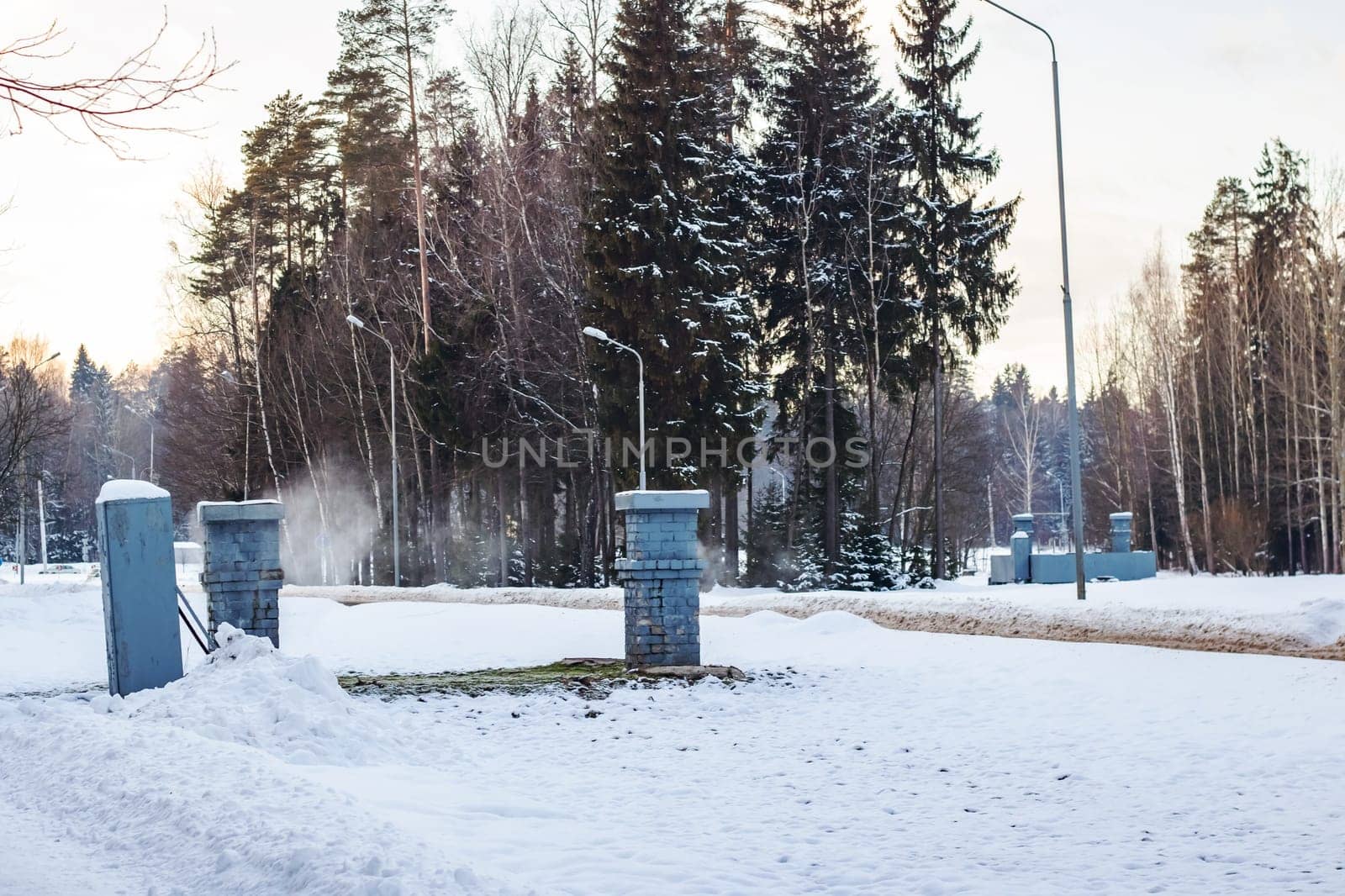 Metal buildings and steam in the winter on forest background