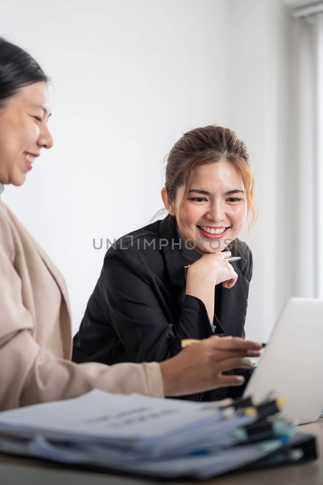 Business woman talking to female coworker, showing project results at meeting. analyze planning and finance statistics and investment market at office in office using pc laptop.