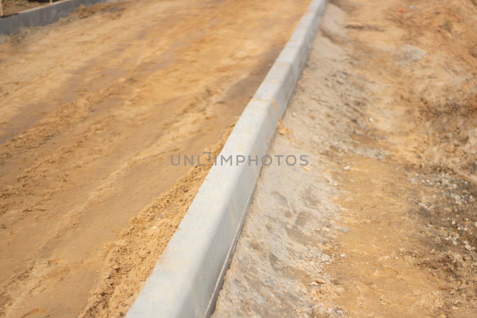 New messes on road. Repair of road. Details of construction works. Concrete blocks are fixed in ground. Background construction sites.a.