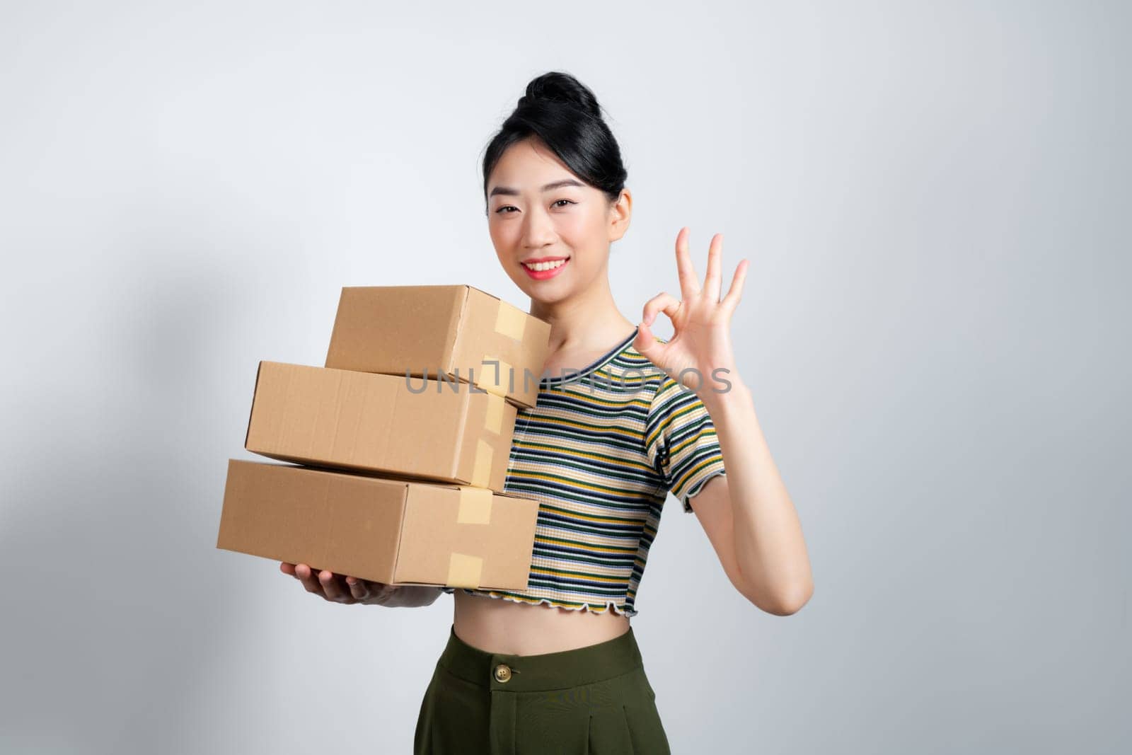 Businesswoman with carry delivery and showing okay sign, white background by makidotvn