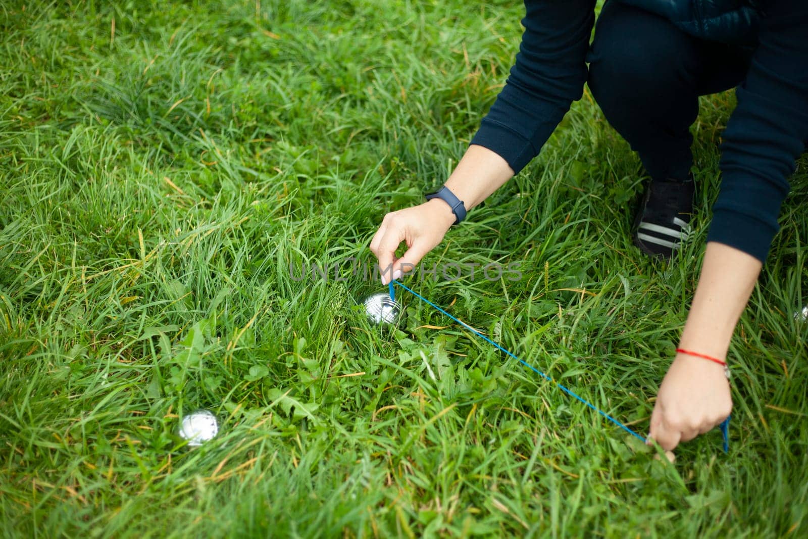 Playing on green grass. Game of steel balls. Sports competition for points. Girls measure accuracy of projectile.