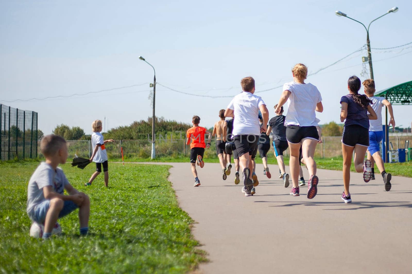 Children compete in running. A lot of kids are racing. Summer sports. Schoolchildren at the physical education lesson. by OlegKopyov