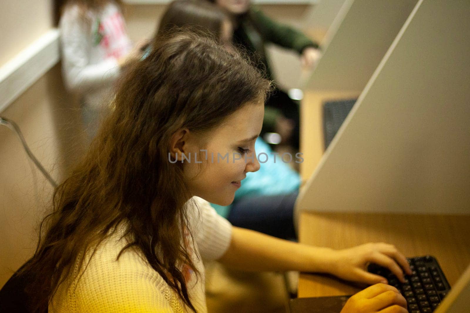 Girl works at computer. Student in classroom. Student types on keyboard. by OlegKopyov