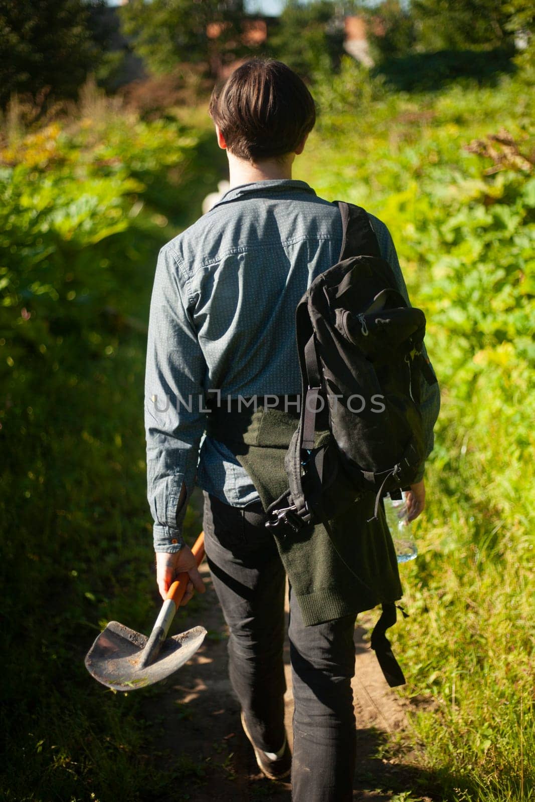 Guy with shovel walks through woods. Man goes to dig ground. by OlegKopyov