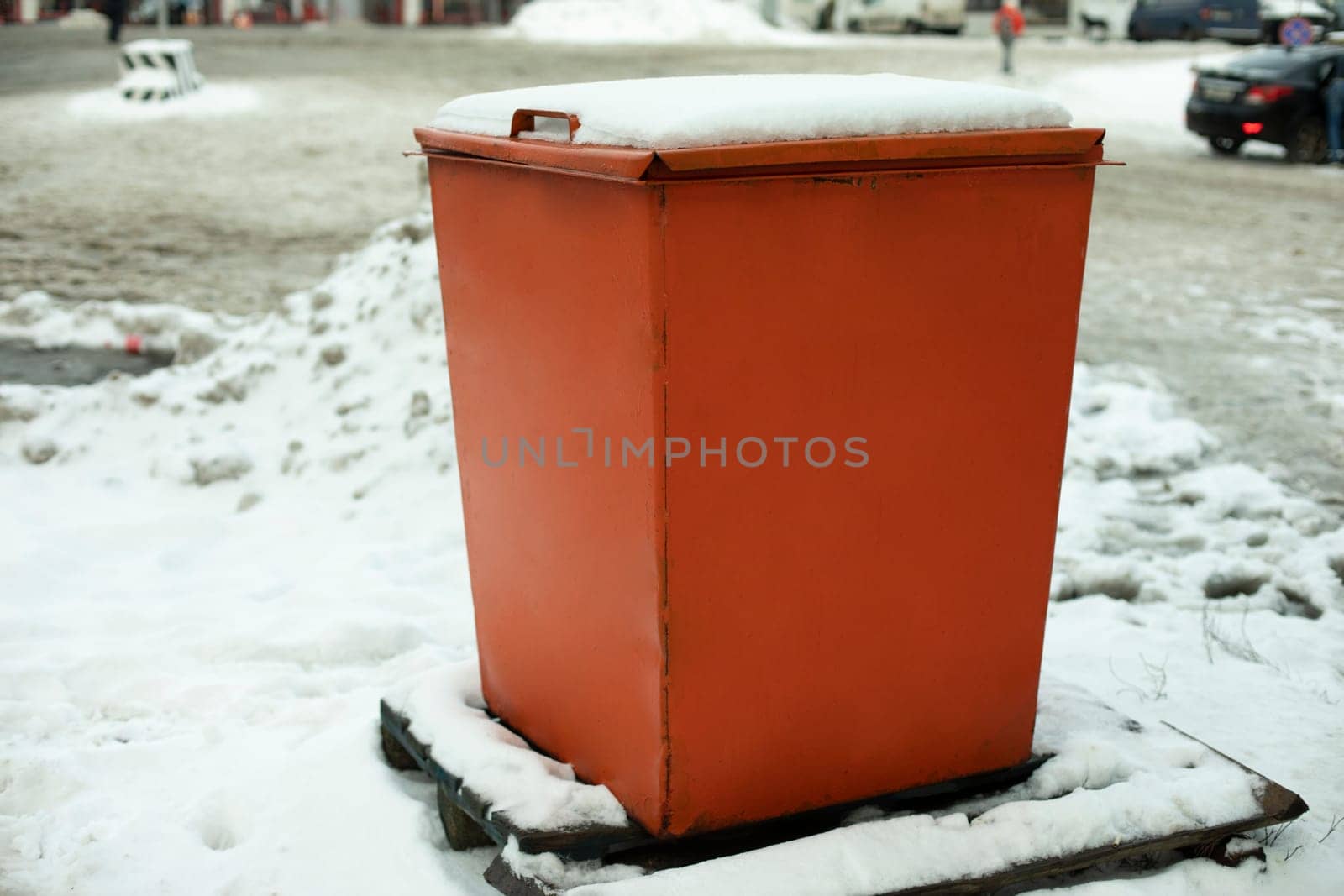 Steel tank. Dumpster. Place to store sand on highway. Orange object in winter on road. Details of road infrastructure.