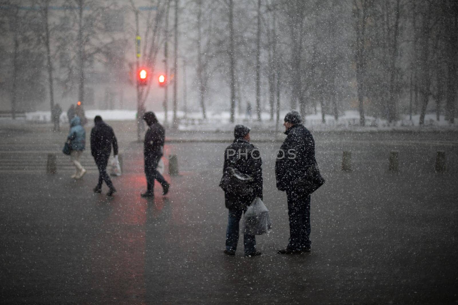 Snow outside. Snowfall in city. People in wet weather. by OlegKopyov