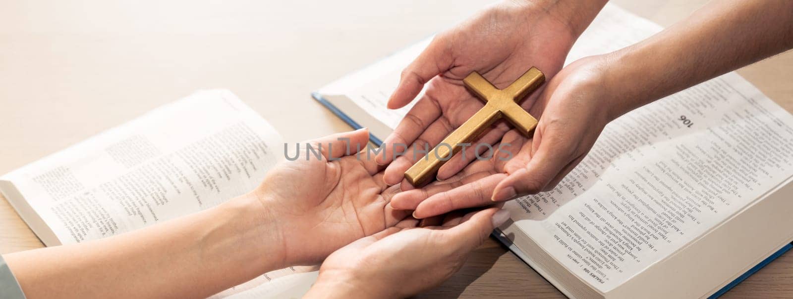 Close-up women prayer deliver holy bible book and holy cross to young believer. Spreading religion symbol. Concept of hope, religion, christianity and god blessing. Warm background. Burgeoning.